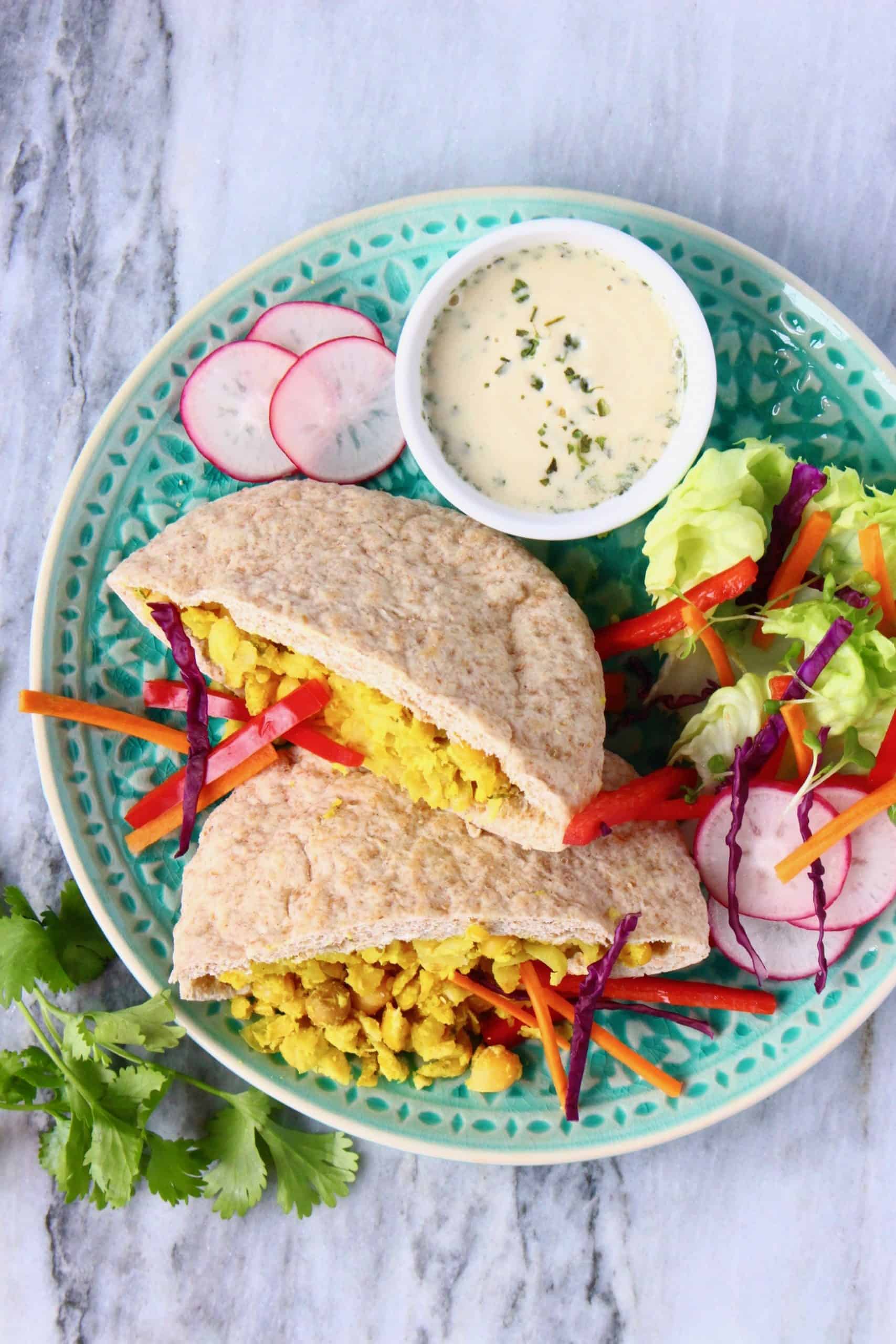 Lazy falafel made with chickpeas in pitta bread with salad and a tahini sauce on a blue plate