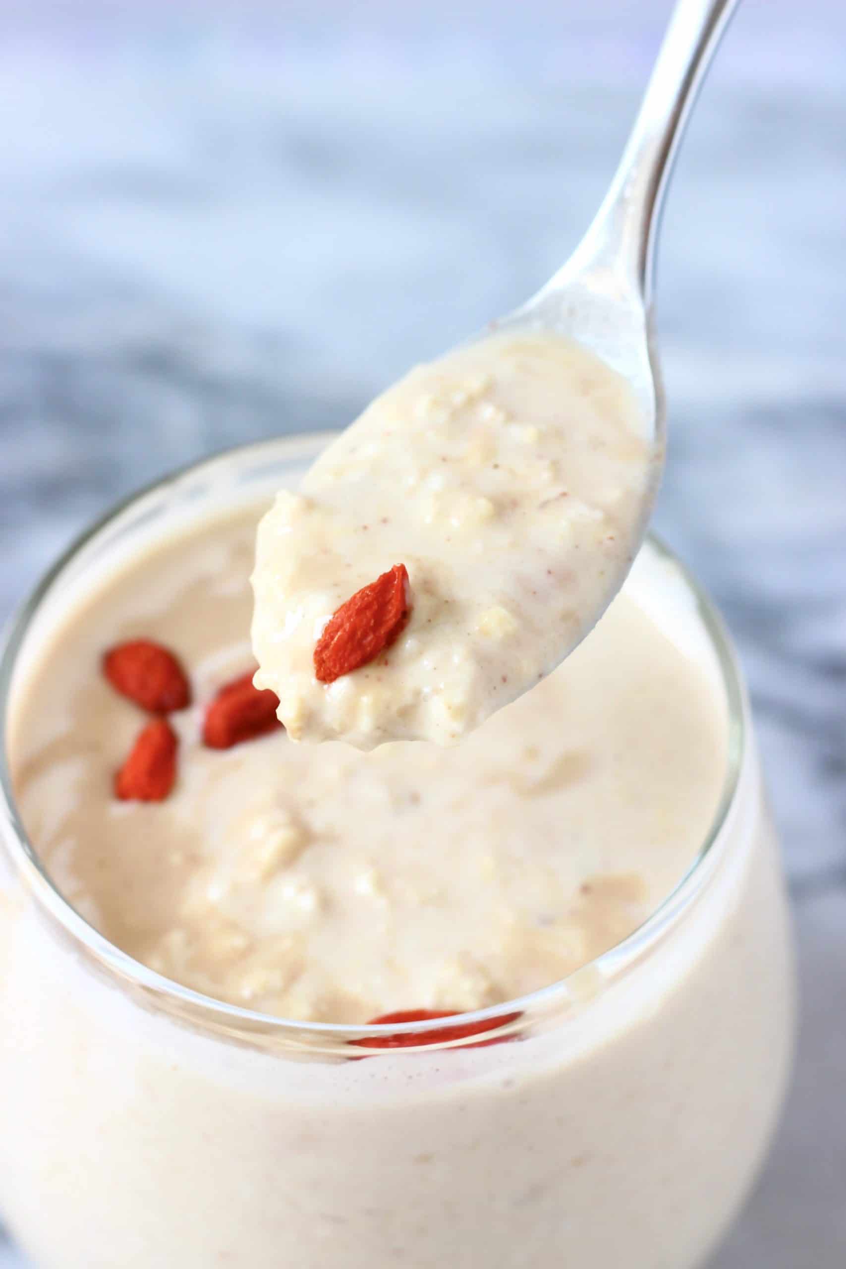 Peanut butter overnight oats in a glass jar with a spoon lifting up a mouthful