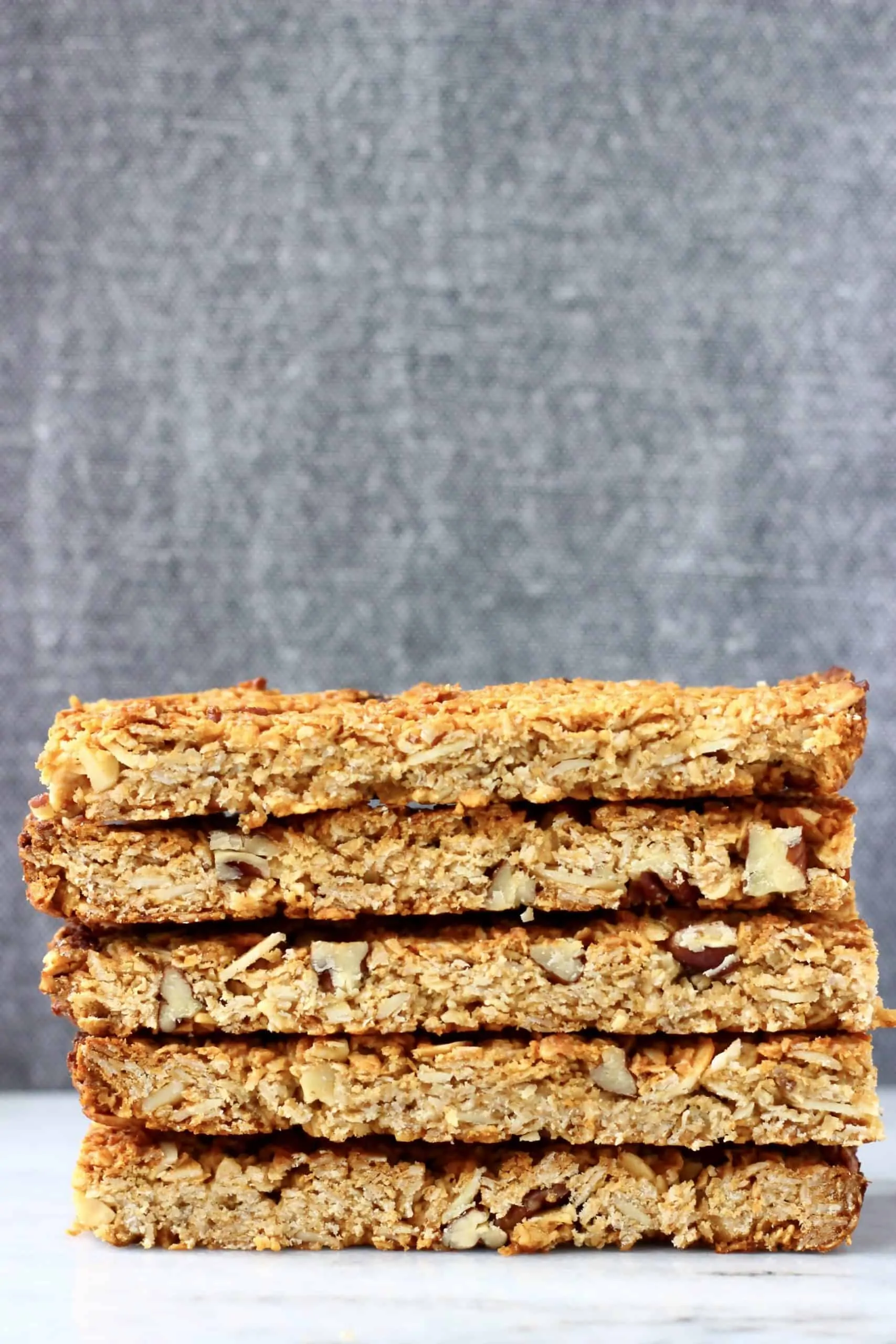 Five golden brown granola bars stacked on top of each other