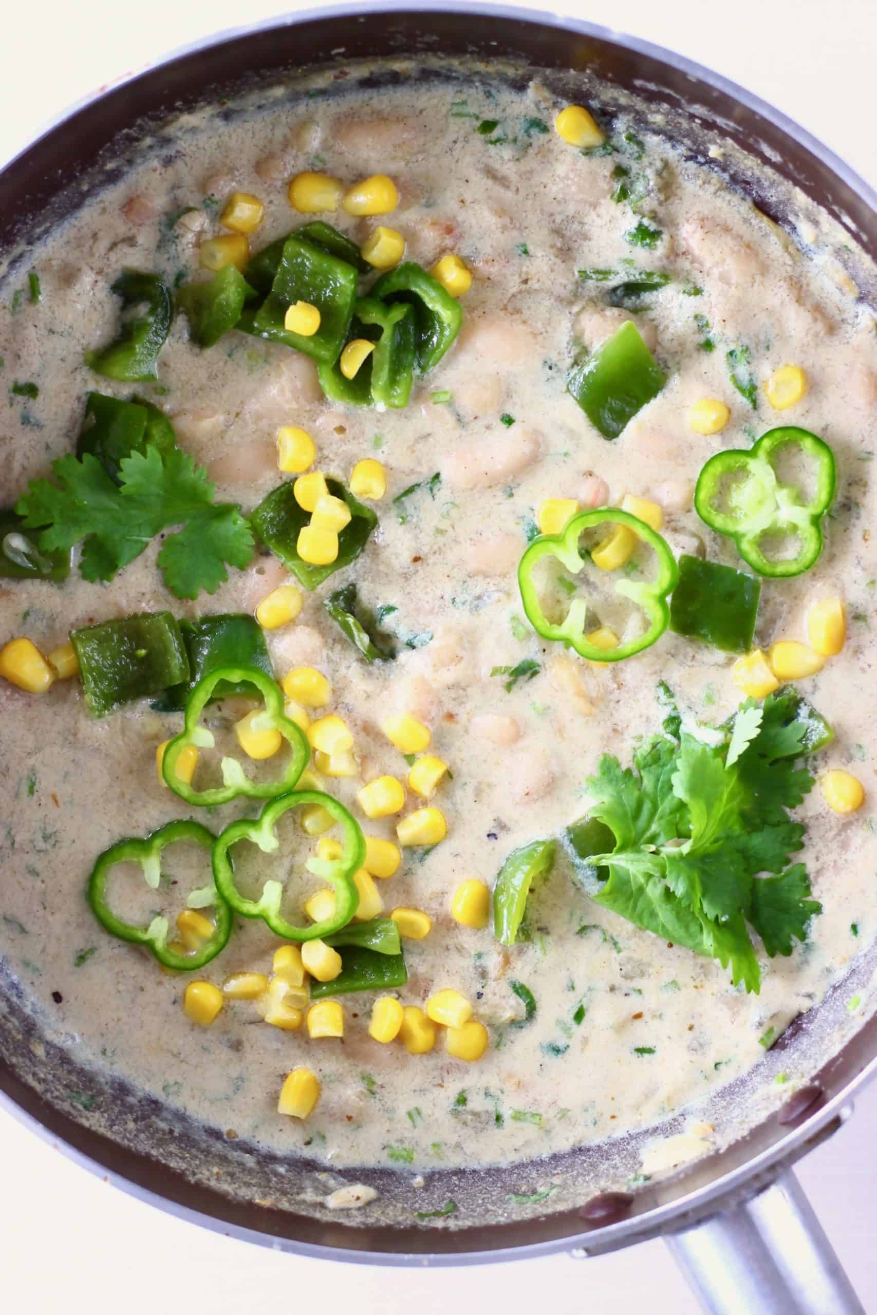 White bean chili with sweetcorn and green pepper in a saucepan