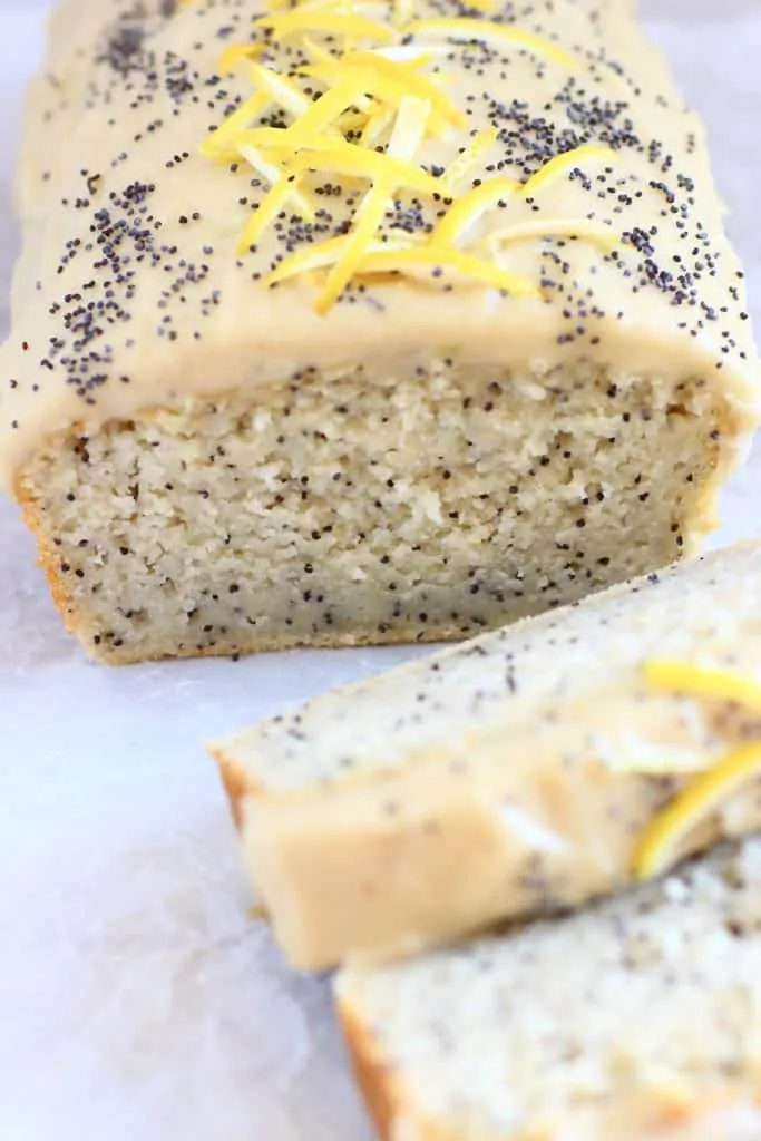 Vegan lemon poppy seed loaf cake topped with cream cheese frosting