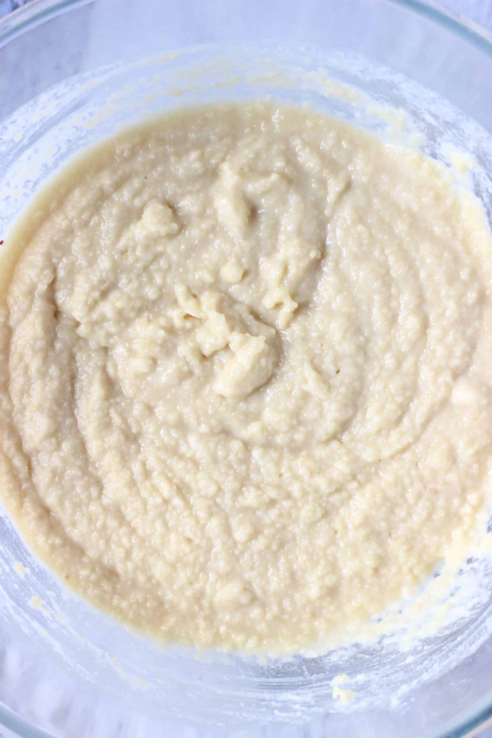 Vegan lemon pudding sponge batter in a glass mixing bowl