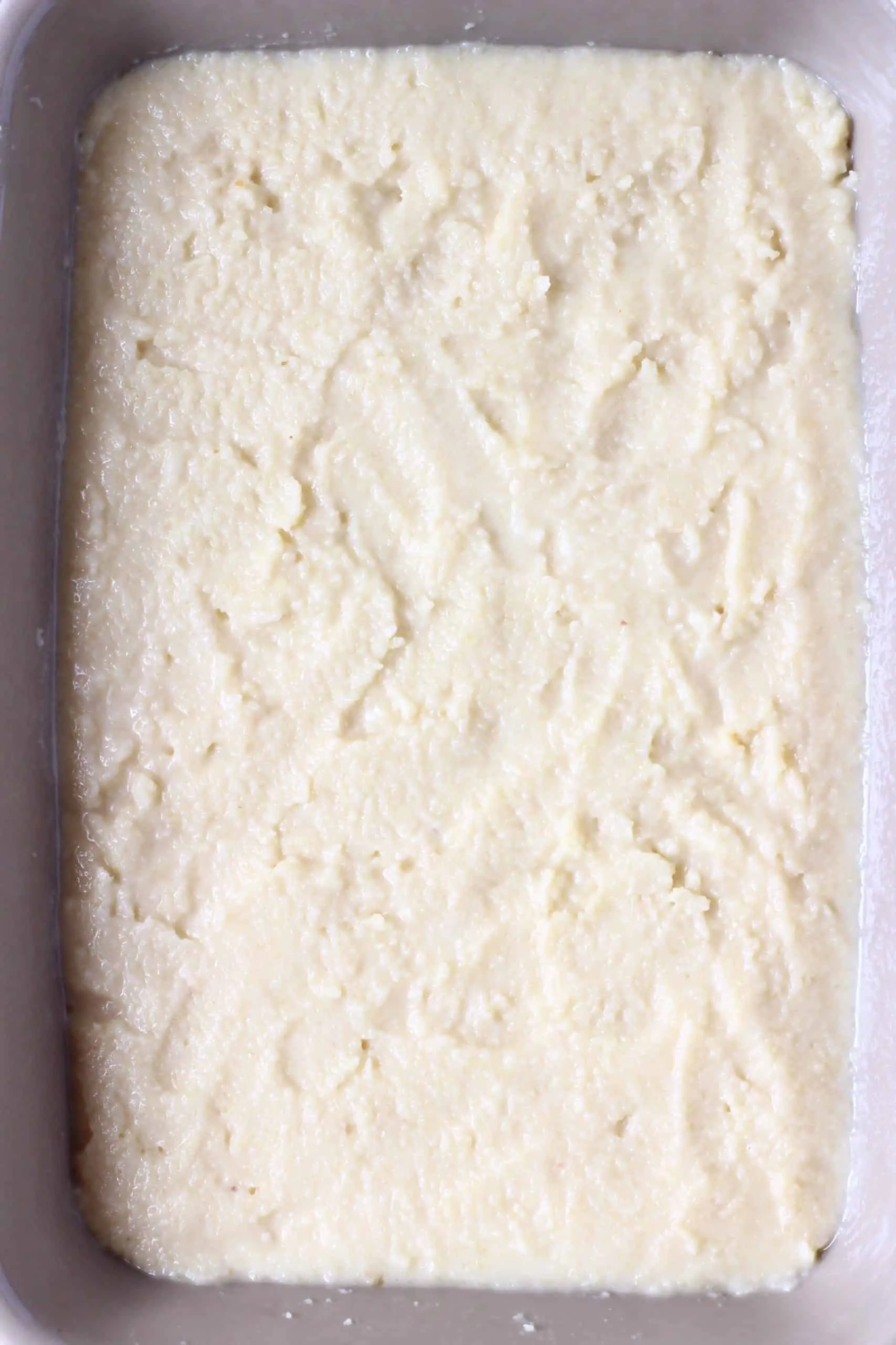 Raw vegan lemon pudding in a grey rectangular baking dish