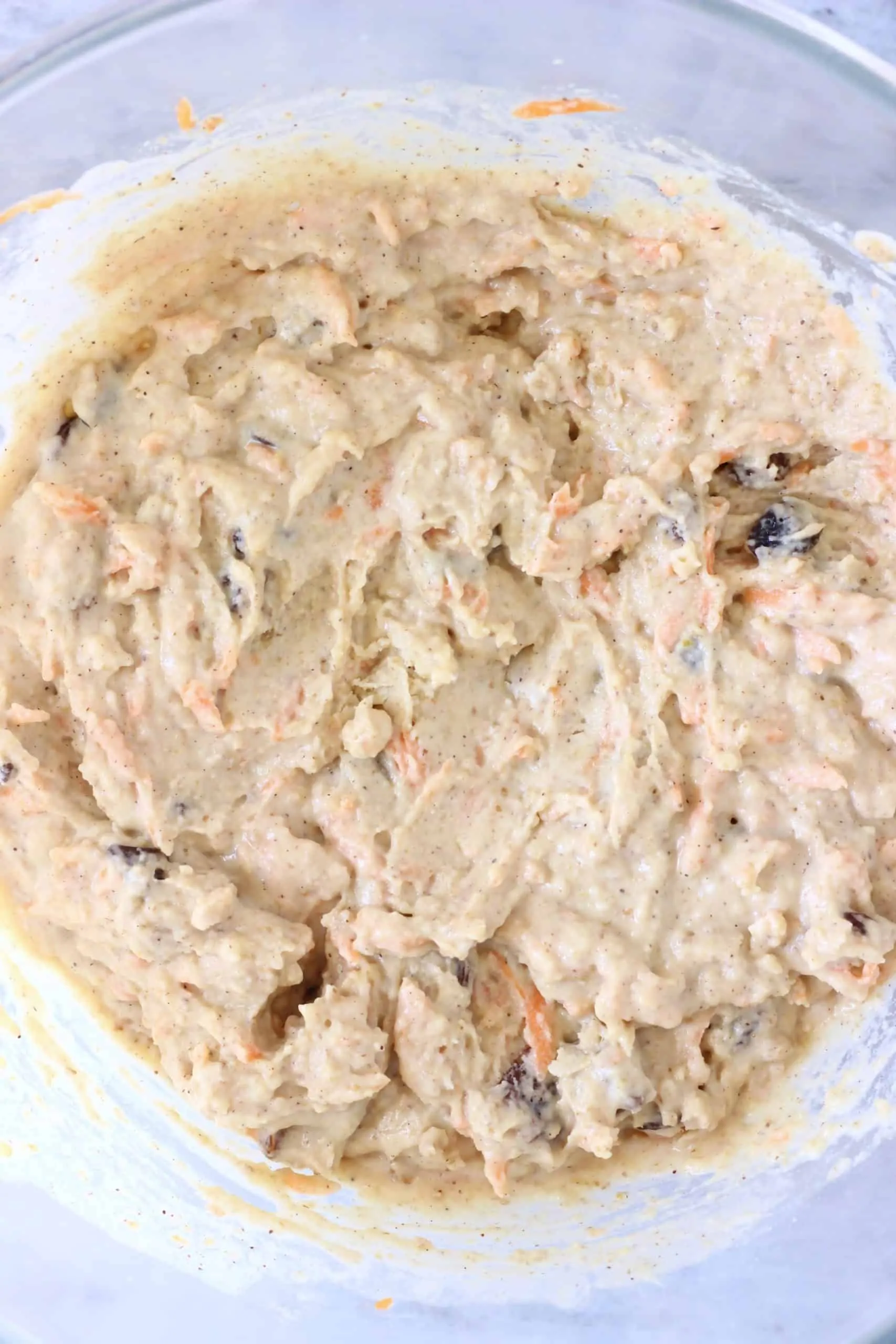 Vegan carrot bread batter in a glass mixing bowl