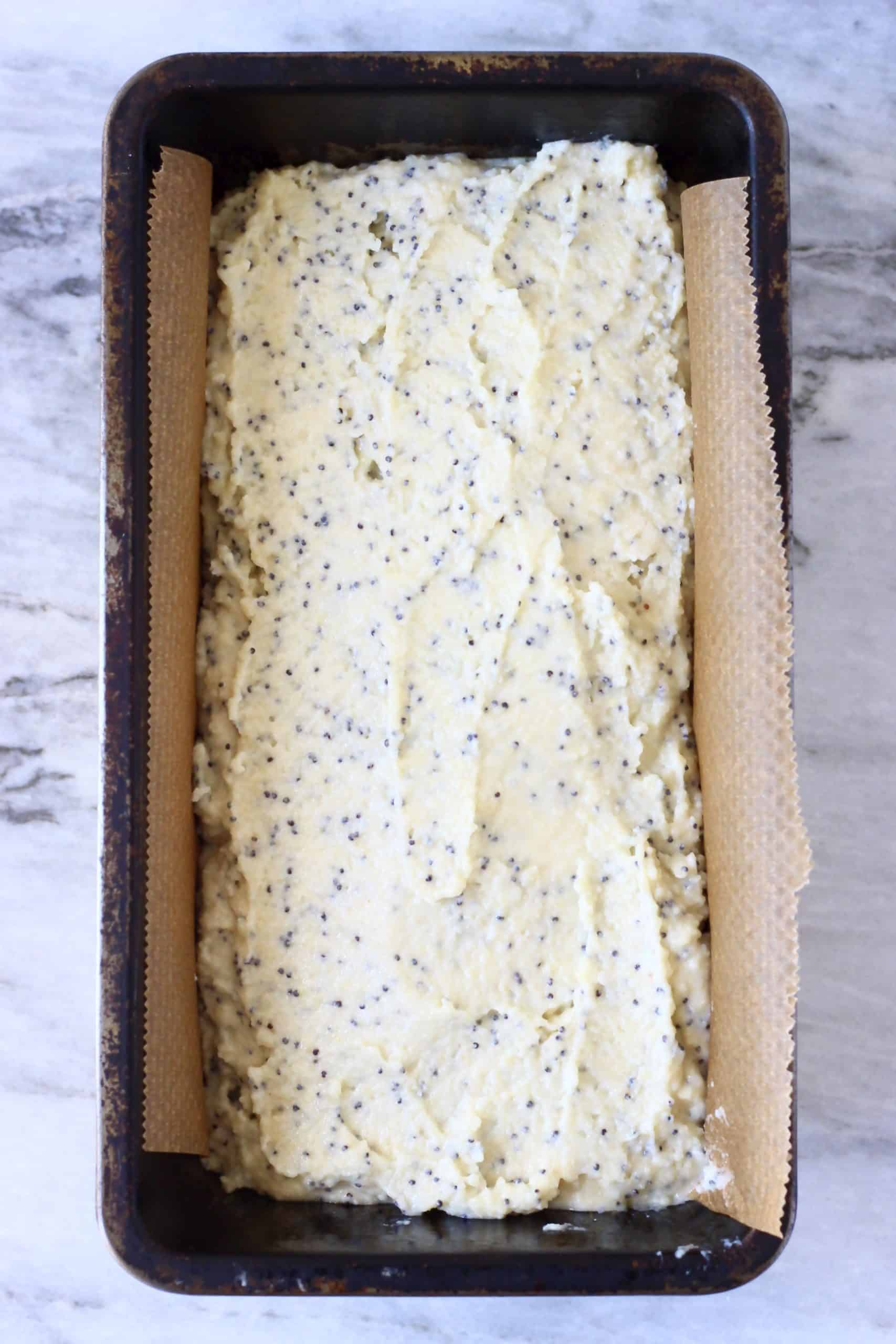 Raw gluten-free vegan lemon poppy seed bread batter in a loaf tin lined with baking paper