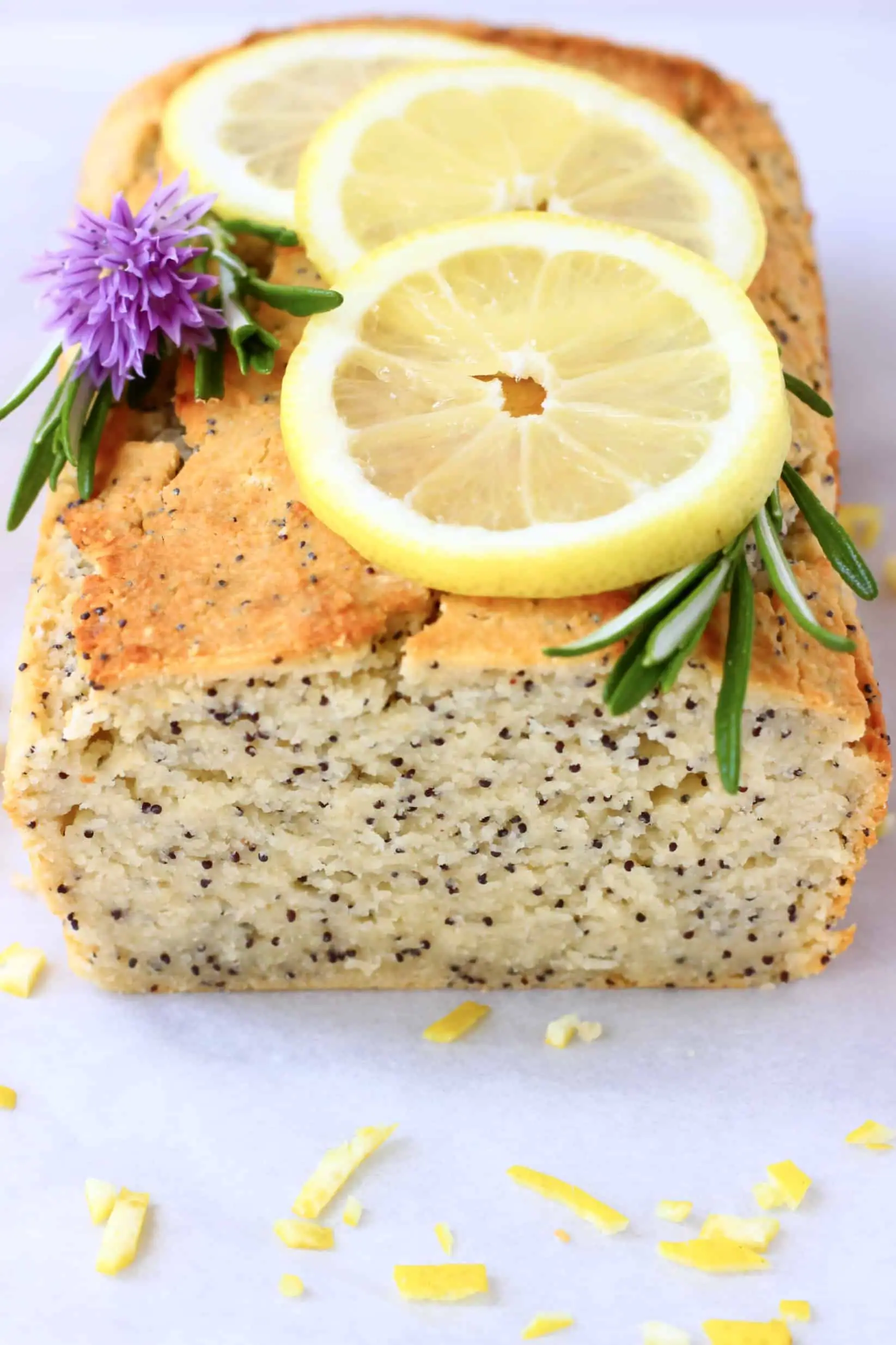 A loaf of gluten-free vegan lemon poppy seed bread topped with lemon slices