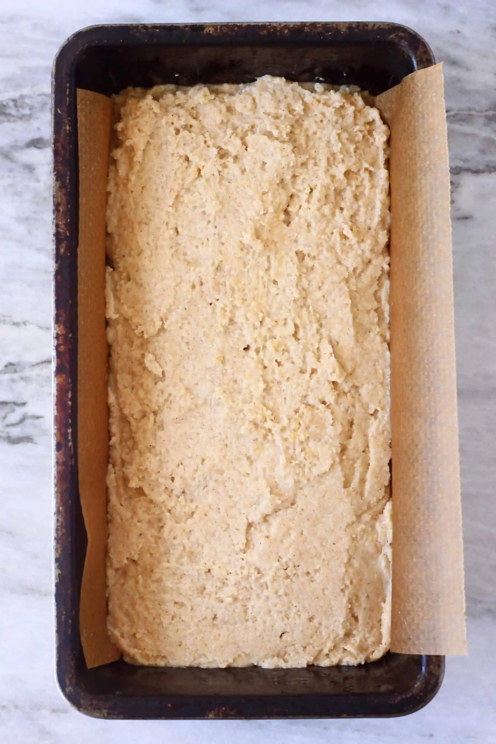 Raw gluten-free vegan peanut butter banana bread batter in a loaf tin