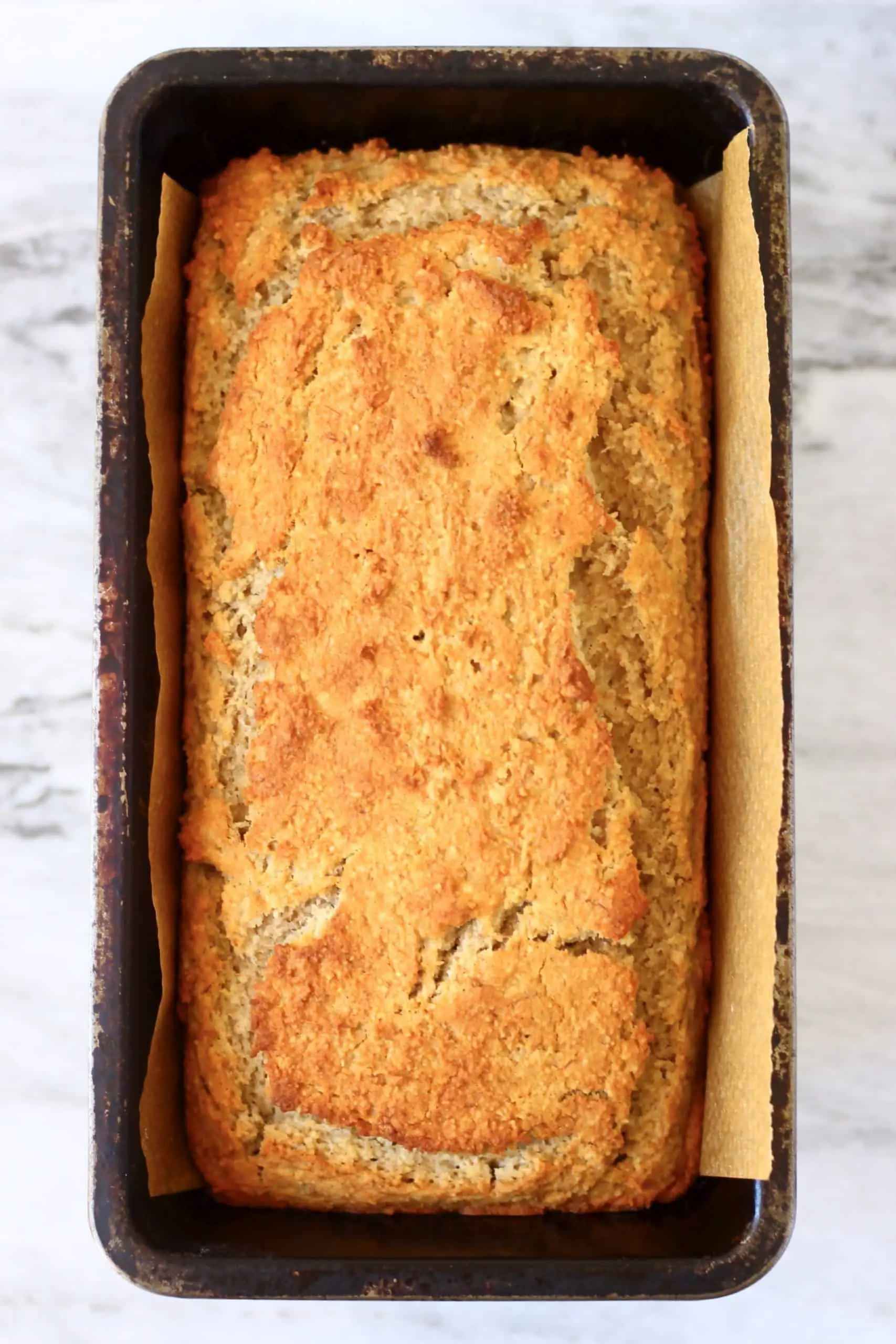 A loaf of gluten-free vegan peanut butter banana bread in a loaf tin