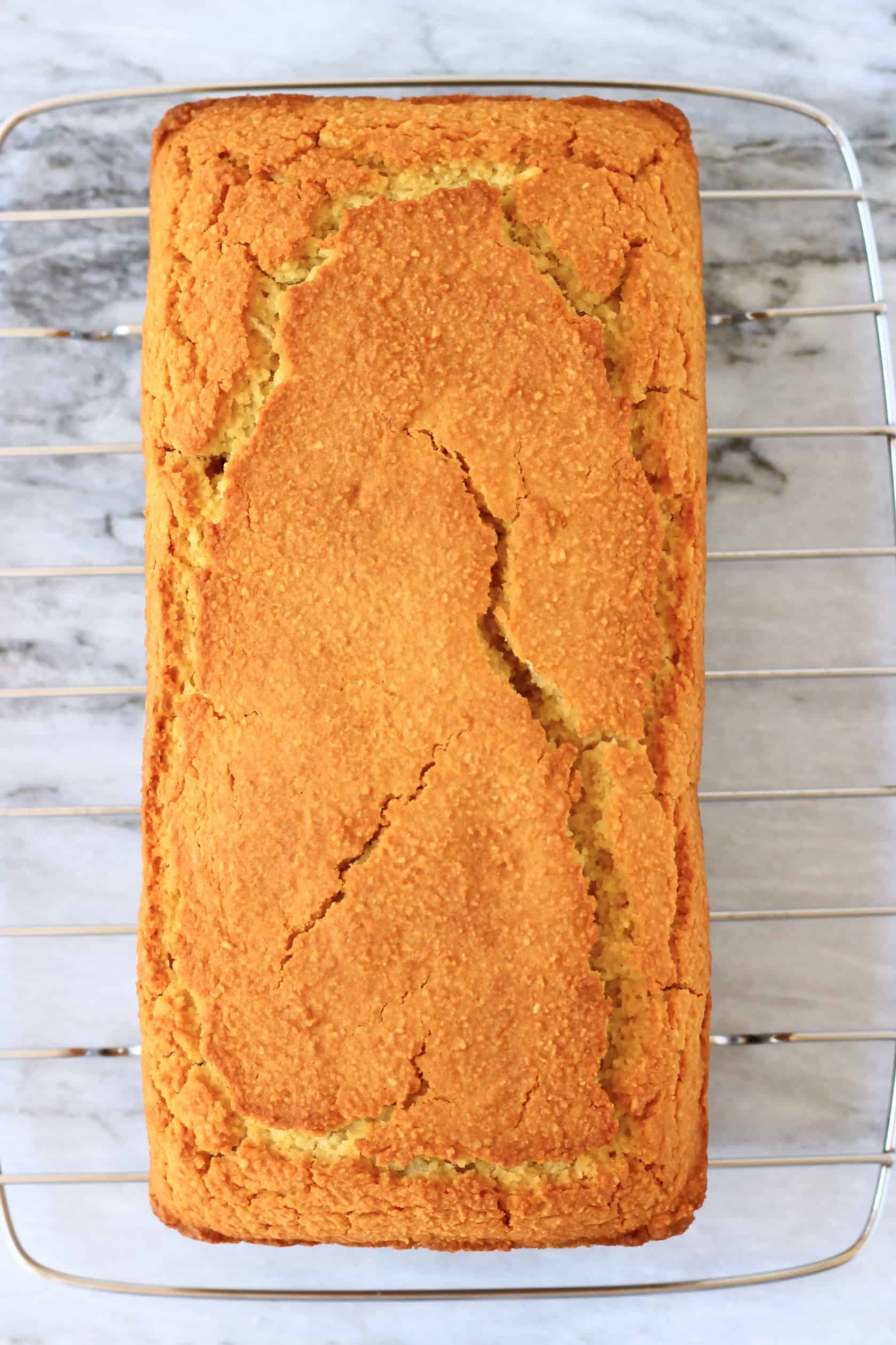 A loaf of gluten-free vegan orange drizzle cake on a wire rack