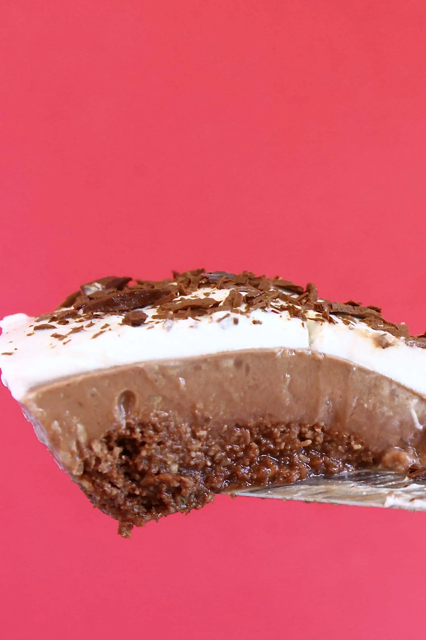 A slice of gluten-free vegan Mississippi mud pie with a chocolate base, chocolate custard and chocolate cream