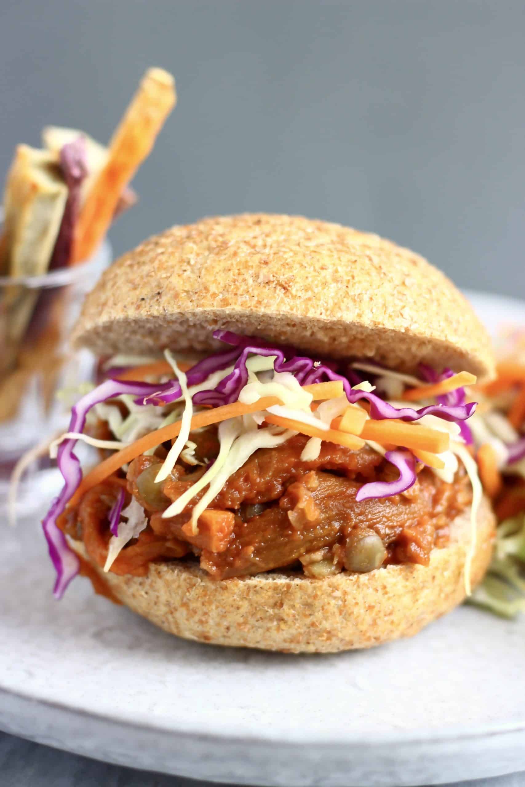 Vegan eggplant pulled pork burger with coleslaw on a white plate