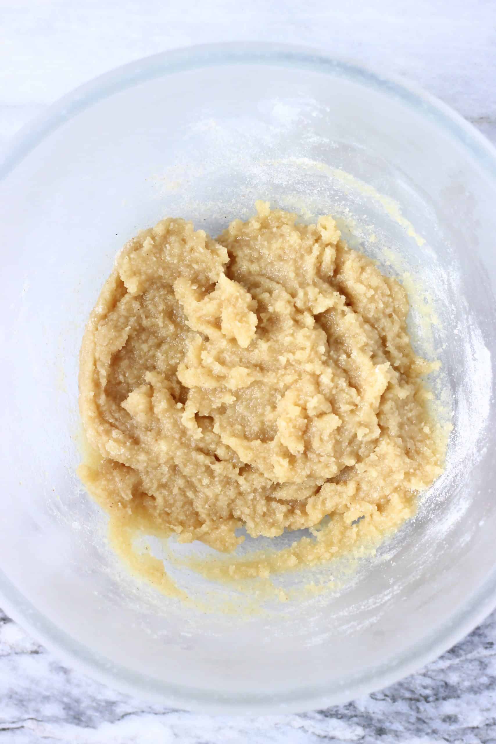 Raw baked cheesecake crust dough in a glass bowl
