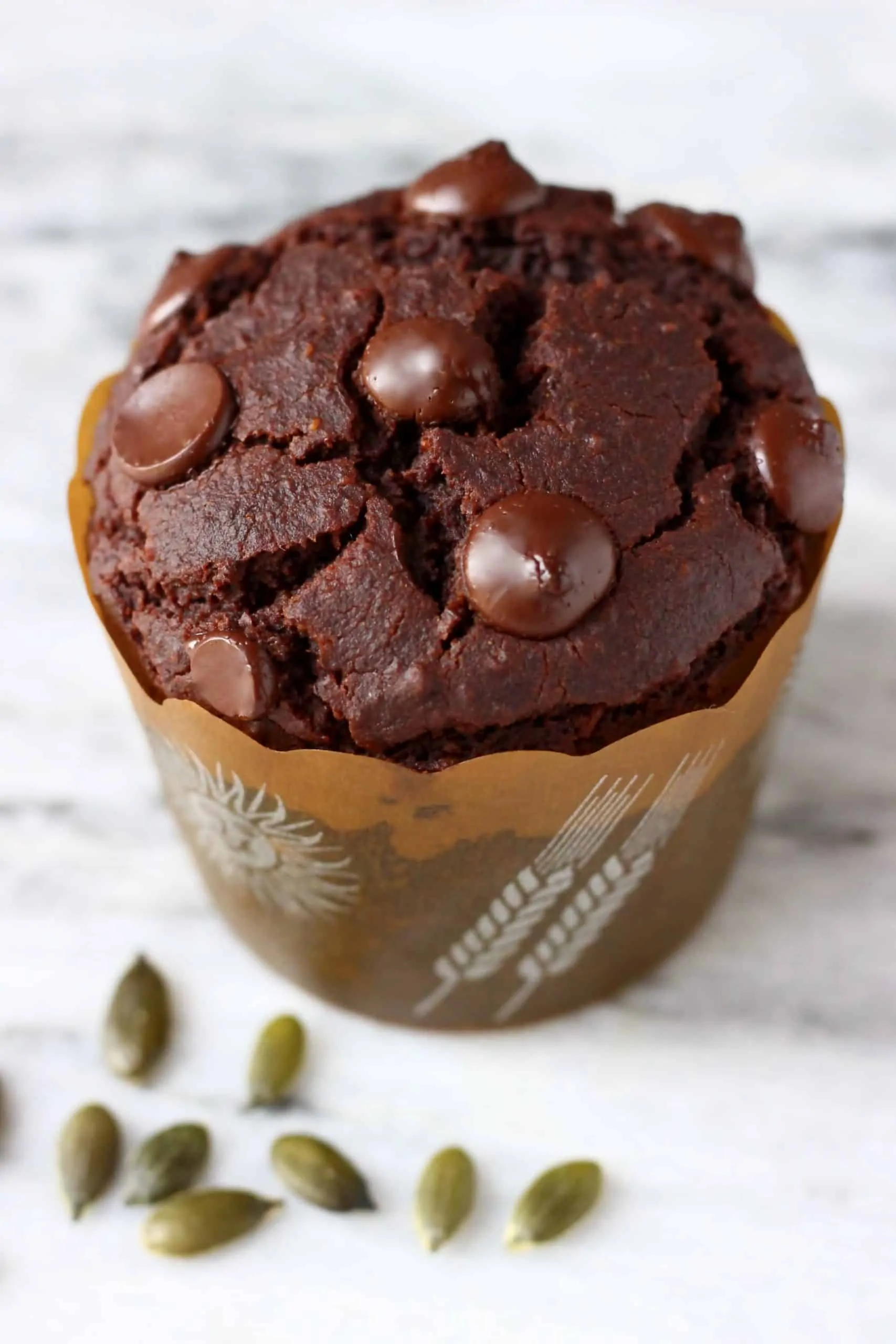 A gluten-free vegan chocolate pumpkin muffin in a brown muffin case