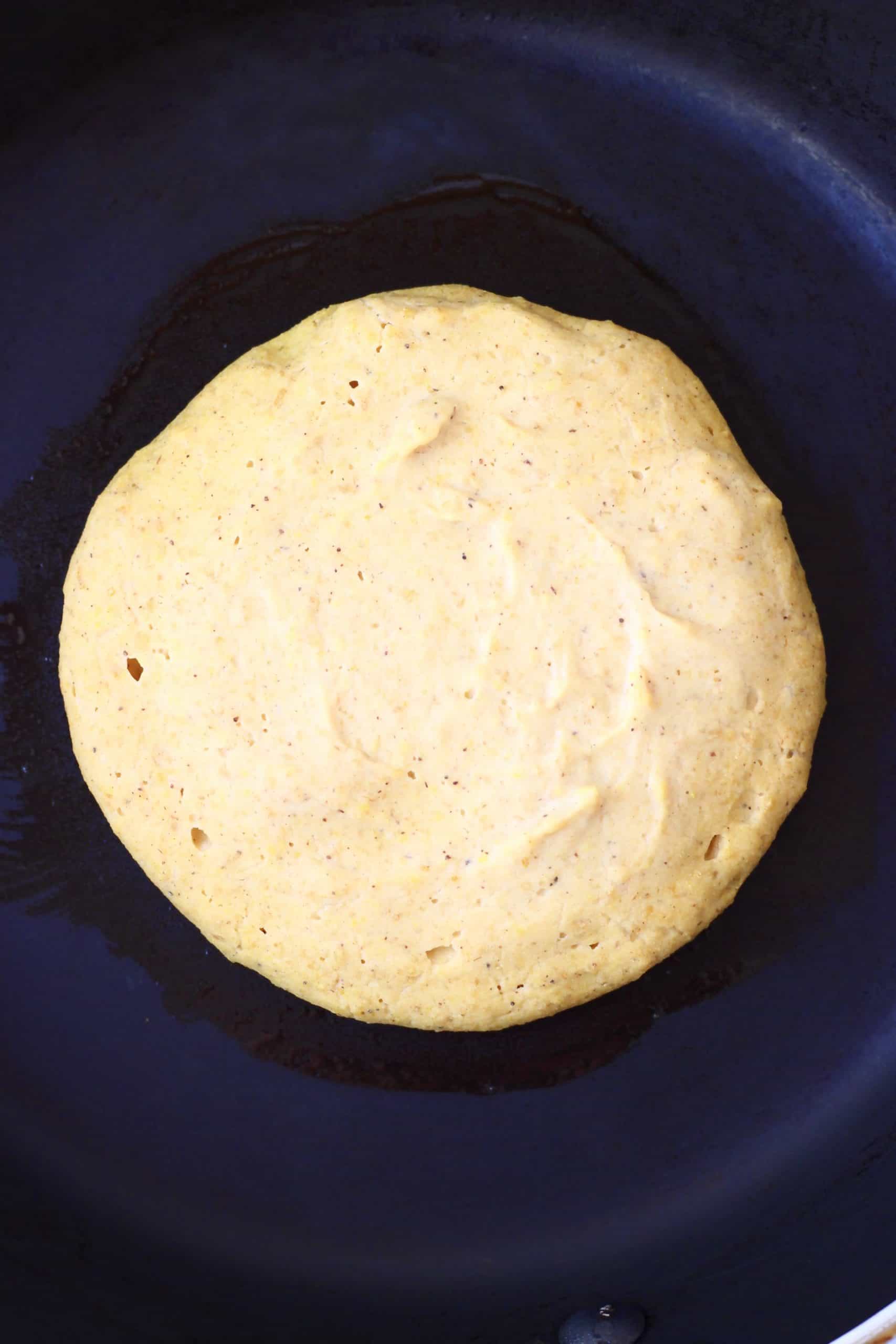 Gluten-free vegan pumpkin pancake batter in a black frying pan