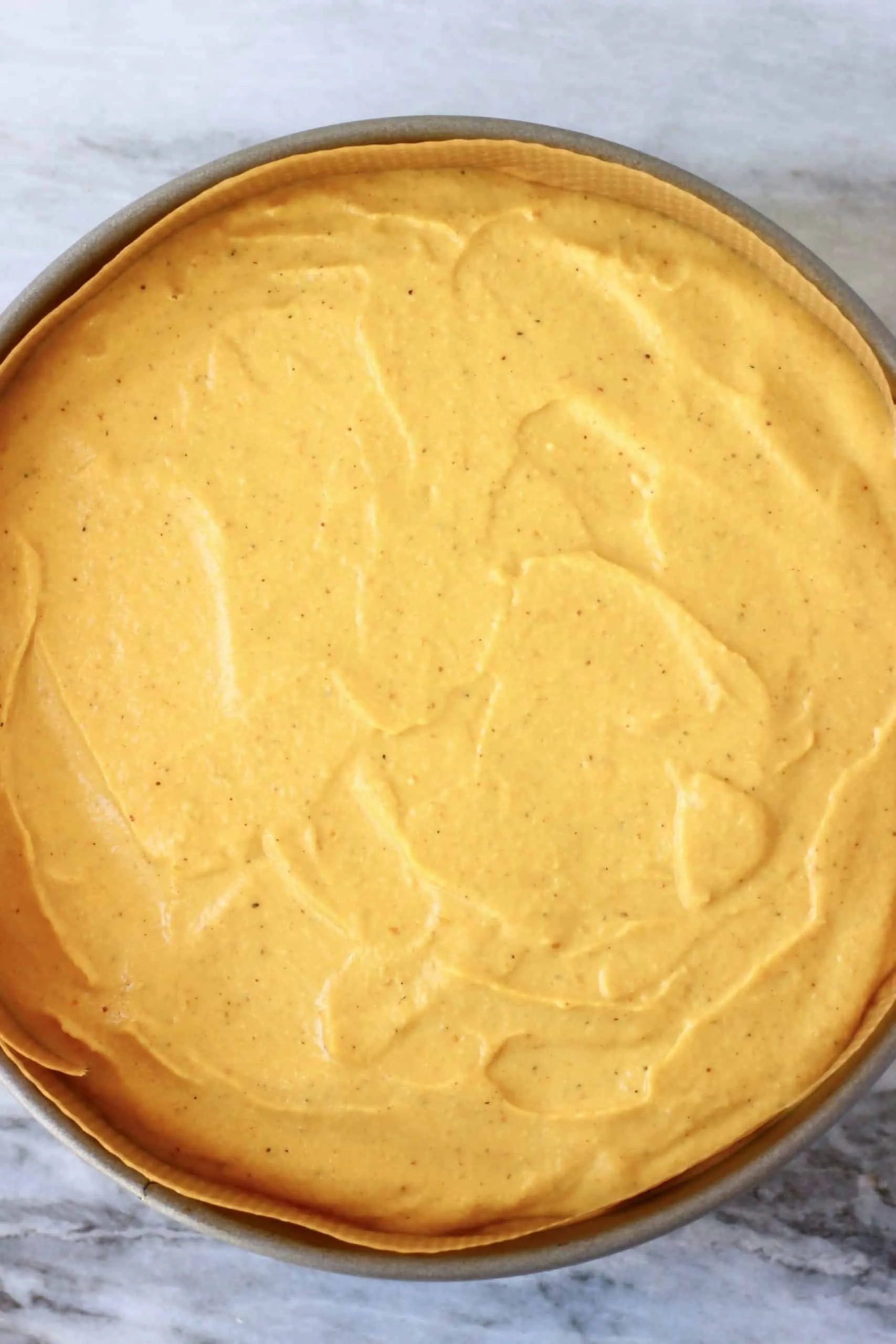 Raw vegan pumpkin cheesecake filling in a springform baking tin