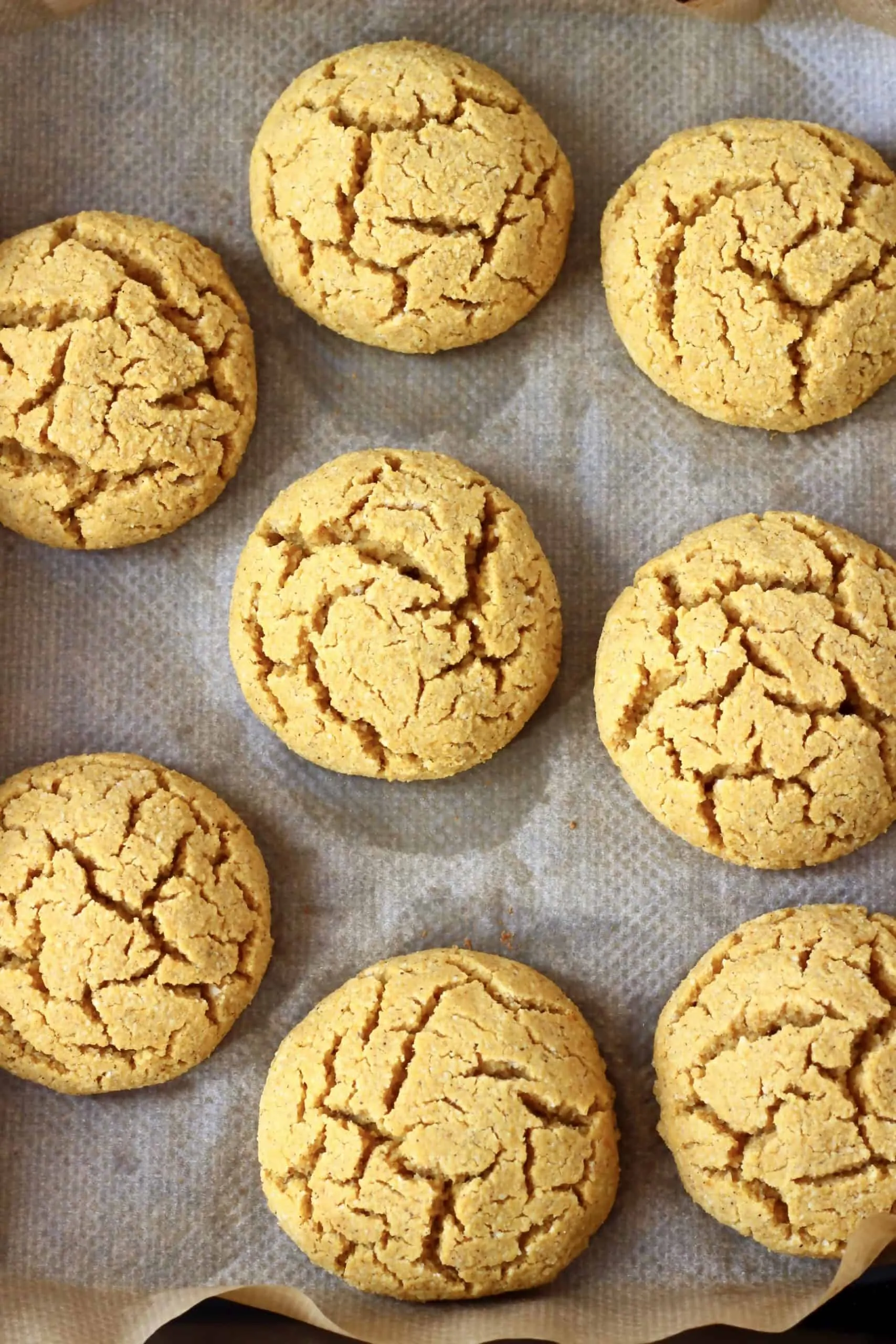 Eight gluten-free vegan pumpkin cookies on a baking tray