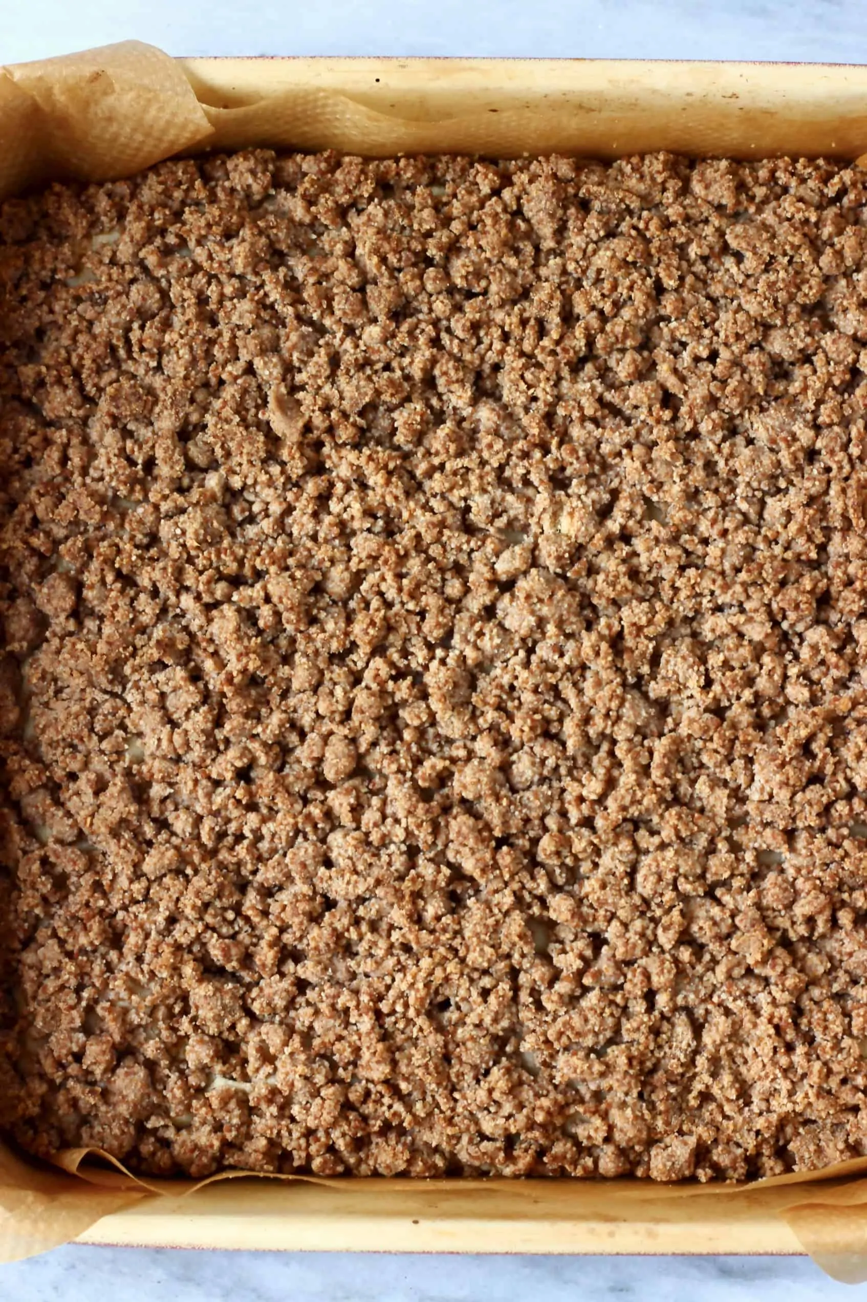 Vegan coffee cake with streusel topping in a square baking tin