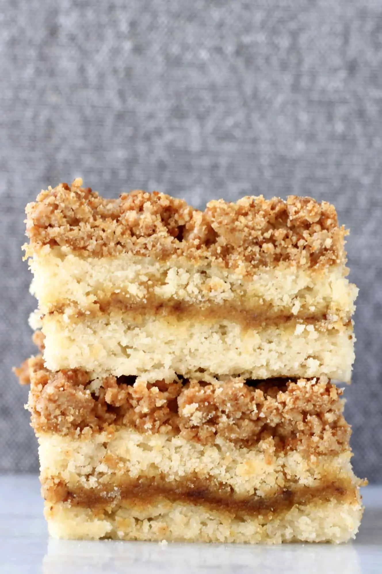Two square slices of vegan coffee cake with streusel topping stacked on top of each other