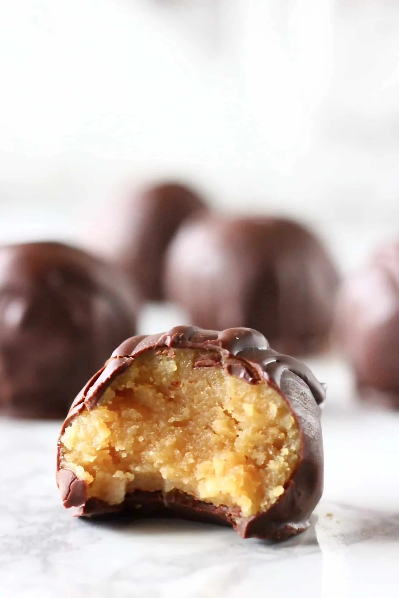 Chocolate-covered peanut butter balls with a bite taken out of one