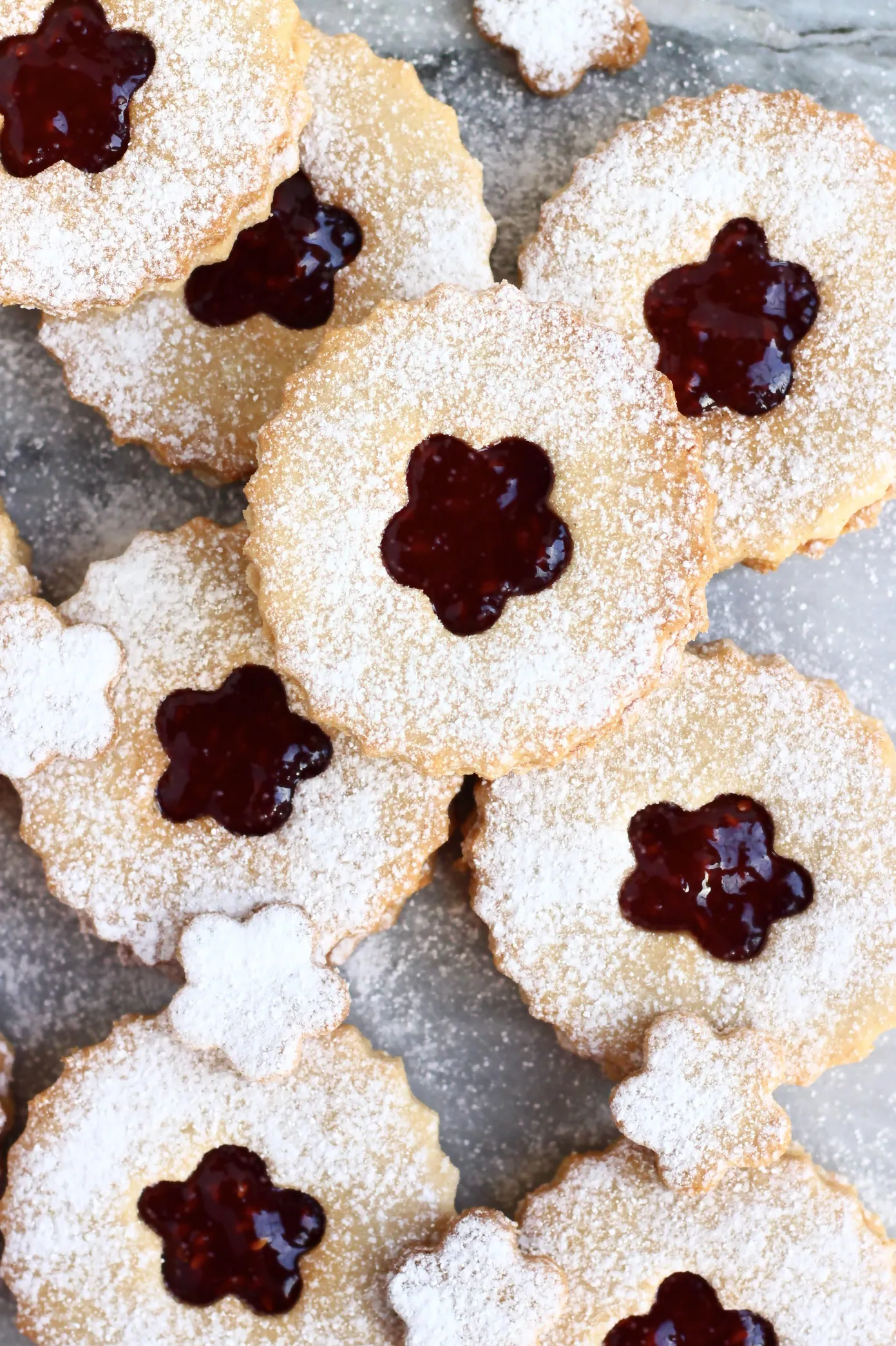 Eight gluten-free vegan linzer cookies filled with raspberry jam