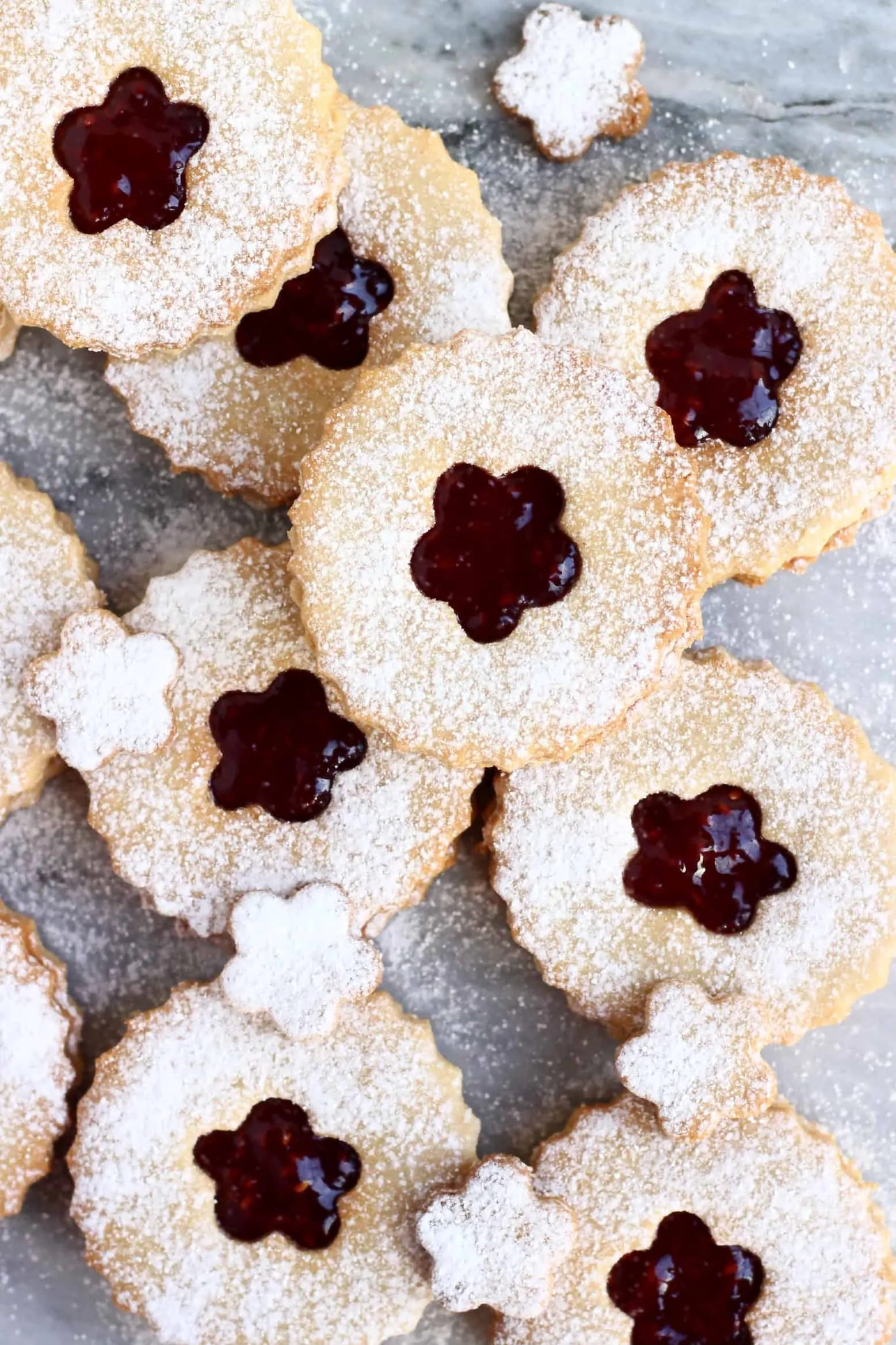 Nine gluten-free vegan linzer cookies filled with raspberry jam