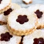 Six gluten-free vegan linzer cookies filled with raspberry jam