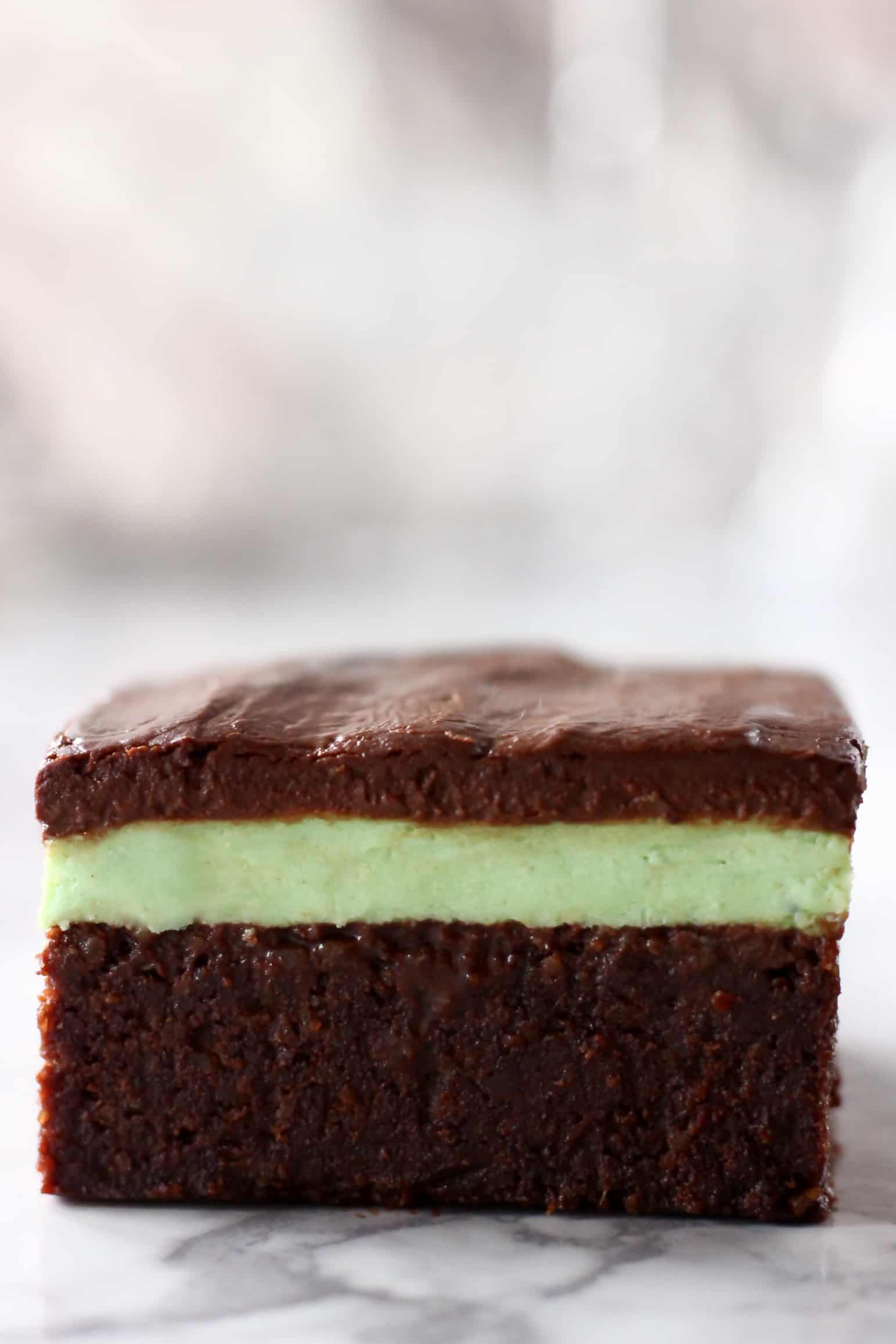 A brownie with green peppermint cream and chocolate ganache
