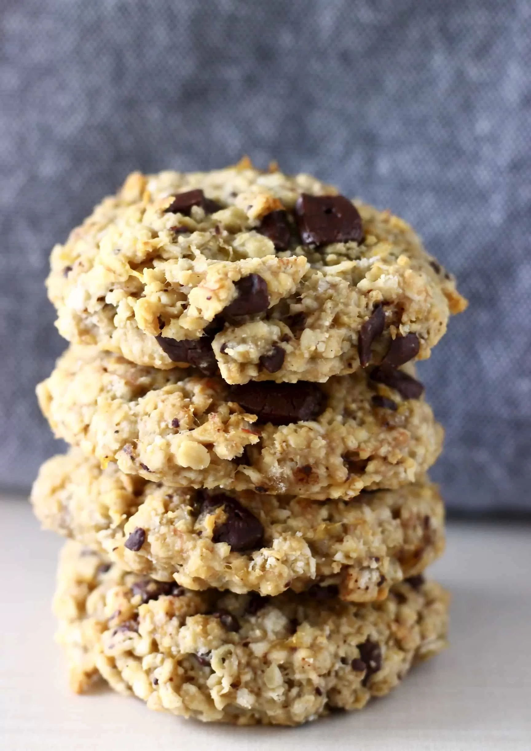 A stack of four gluten-free vegan banana oatmeal cookies with chocolate chips