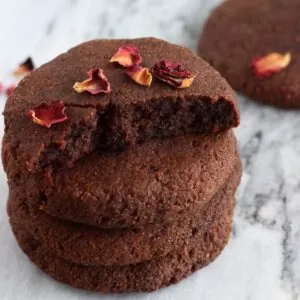 A stack of gluten-free vegan chocolate brownie cookies on a marble background