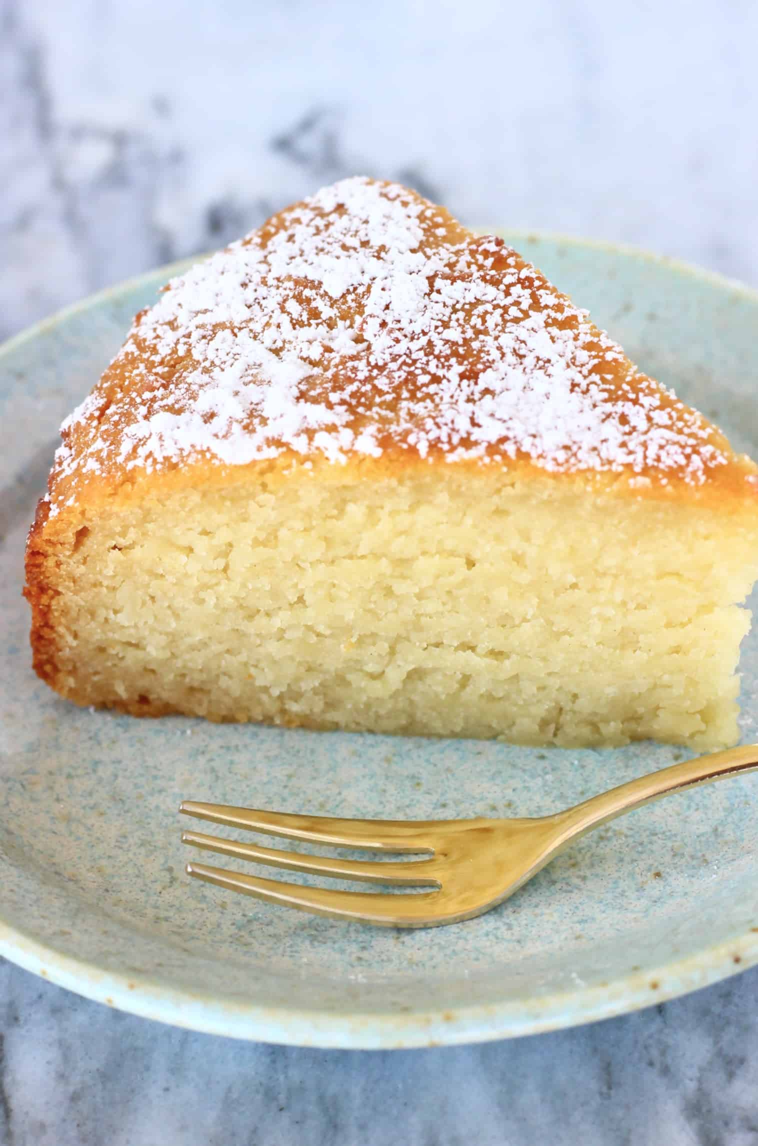A slice of gluten-free vegan yogurt cake on a plate with a fork