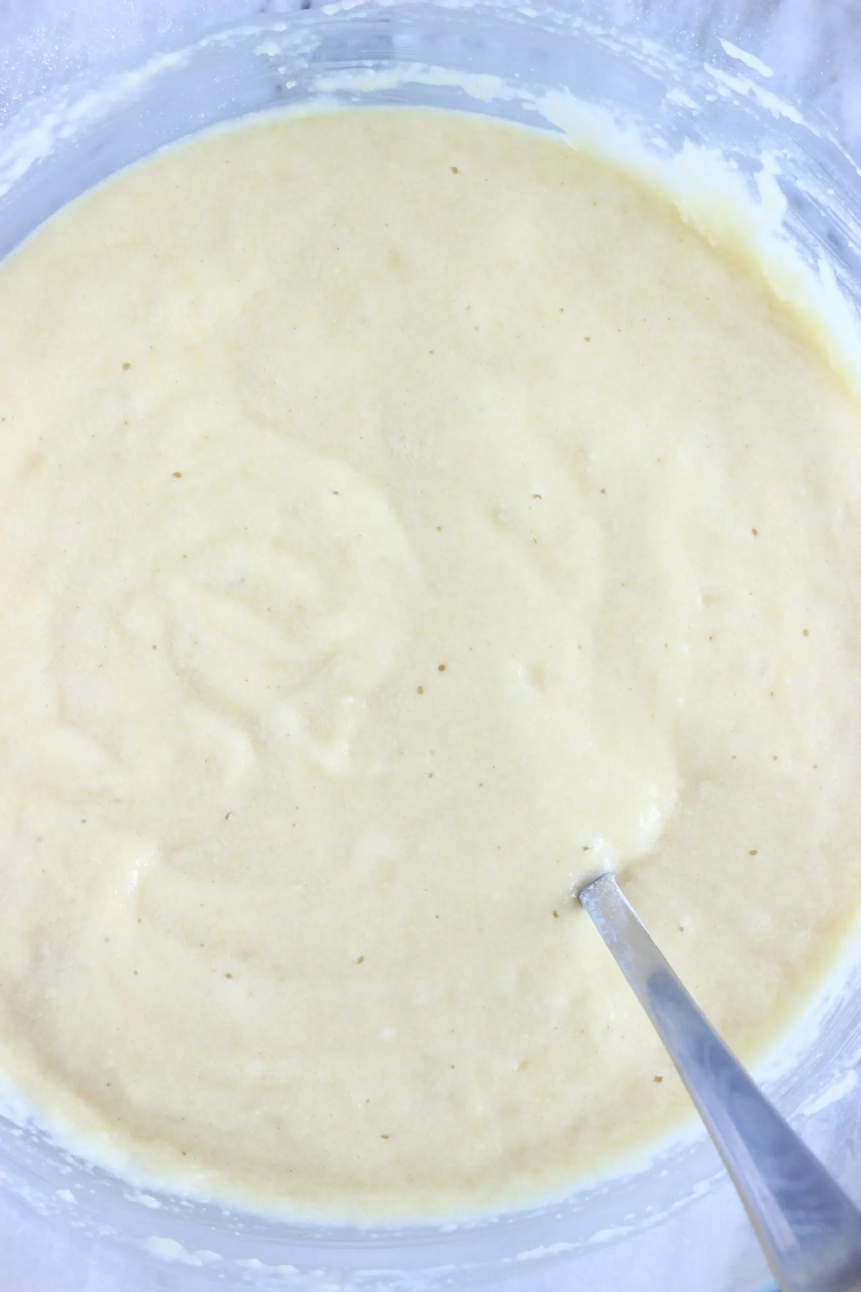 Raw vegan lemon drizzle loaf cake batter in a bowl with a spoon