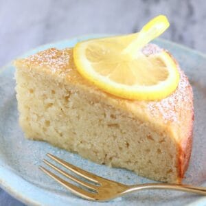 A slice of gluten-free vegan lemon yogurt cake on a plate with a fork