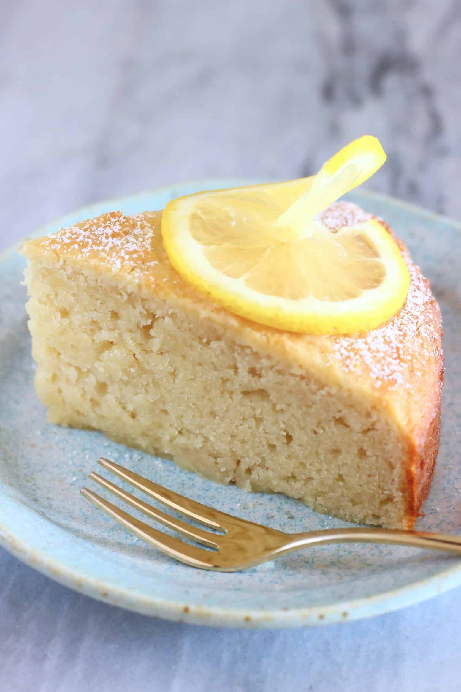 A slice of gluten-free vegan lemon yogurt cake on a plate with a fork