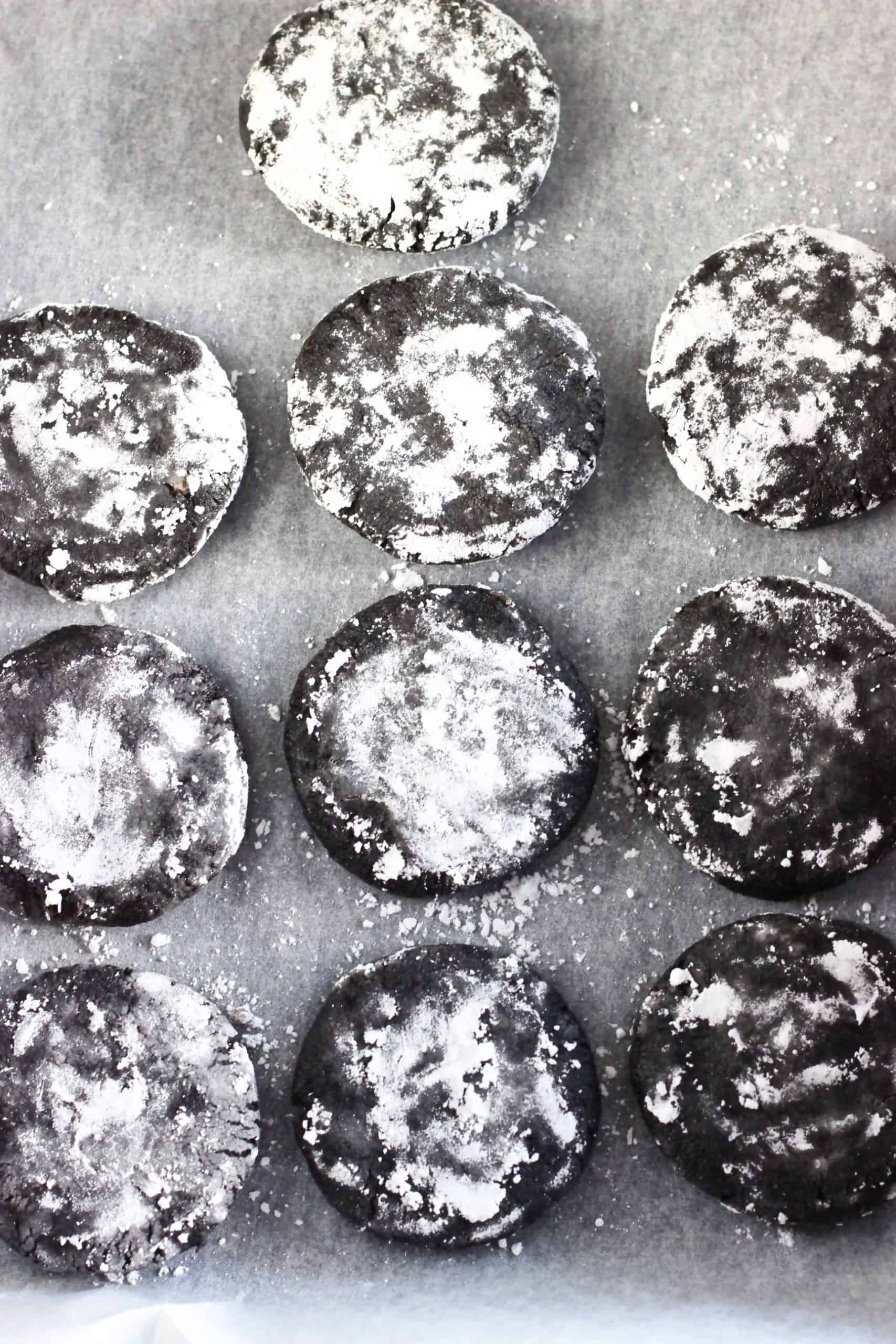 10 raw gluten-free vegan chocolate crinkle cookies on a baking tray lined with baking paper
