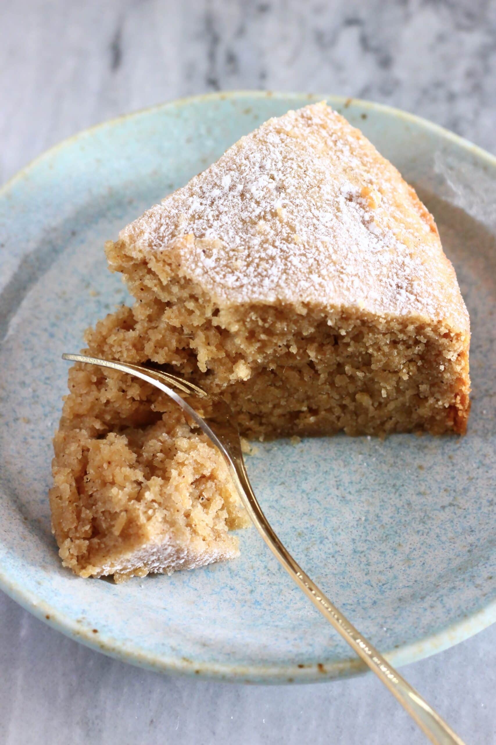 A slice of gluten-free vegan ginger cake with a fork taking a bite