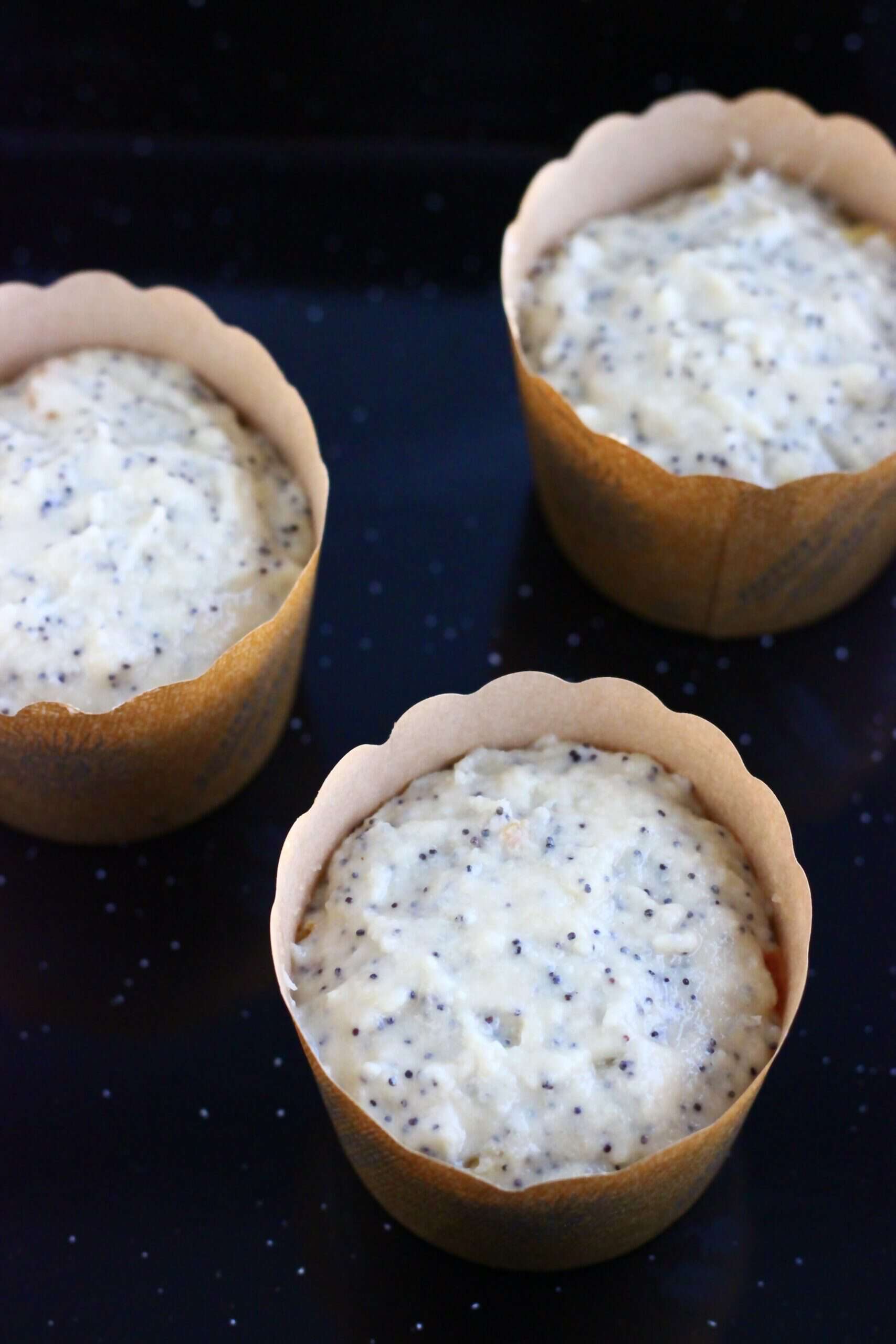 Raw gluten-free vegan orange poppy seed muffins batter in muffin cases