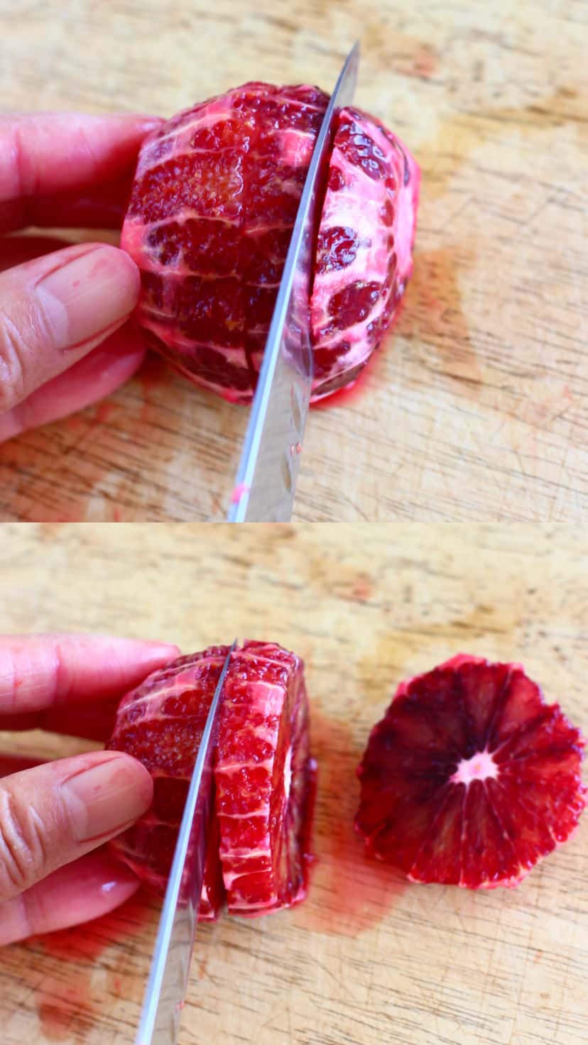 A peeled blood orange being cut into slices with a knife