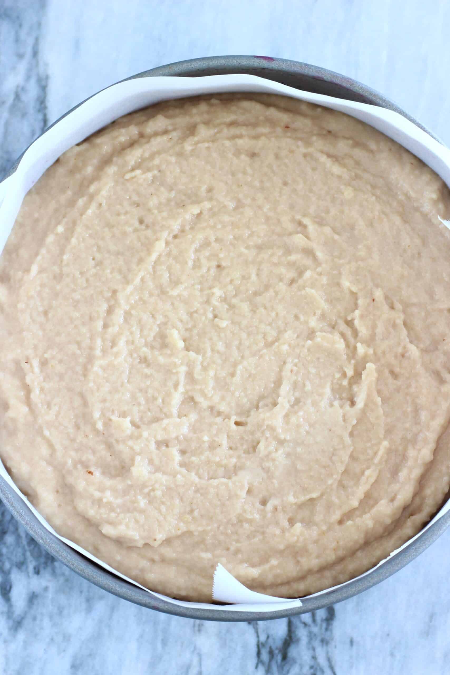 Raw gluten-free vegan blood orange cake batter in a round springform baking tin lined with baking paper