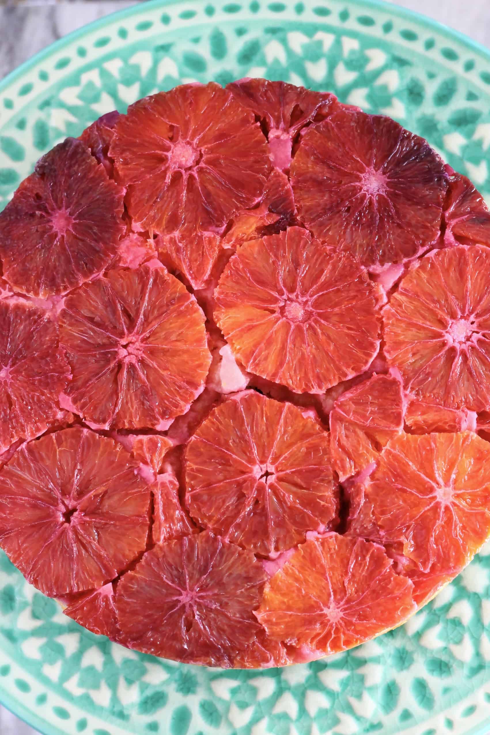 A gluten-free vegan blood orange upside down cake upturned onto a cake stand