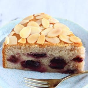 A slice of gluten-free vegan cherry cake on a plate with a fork