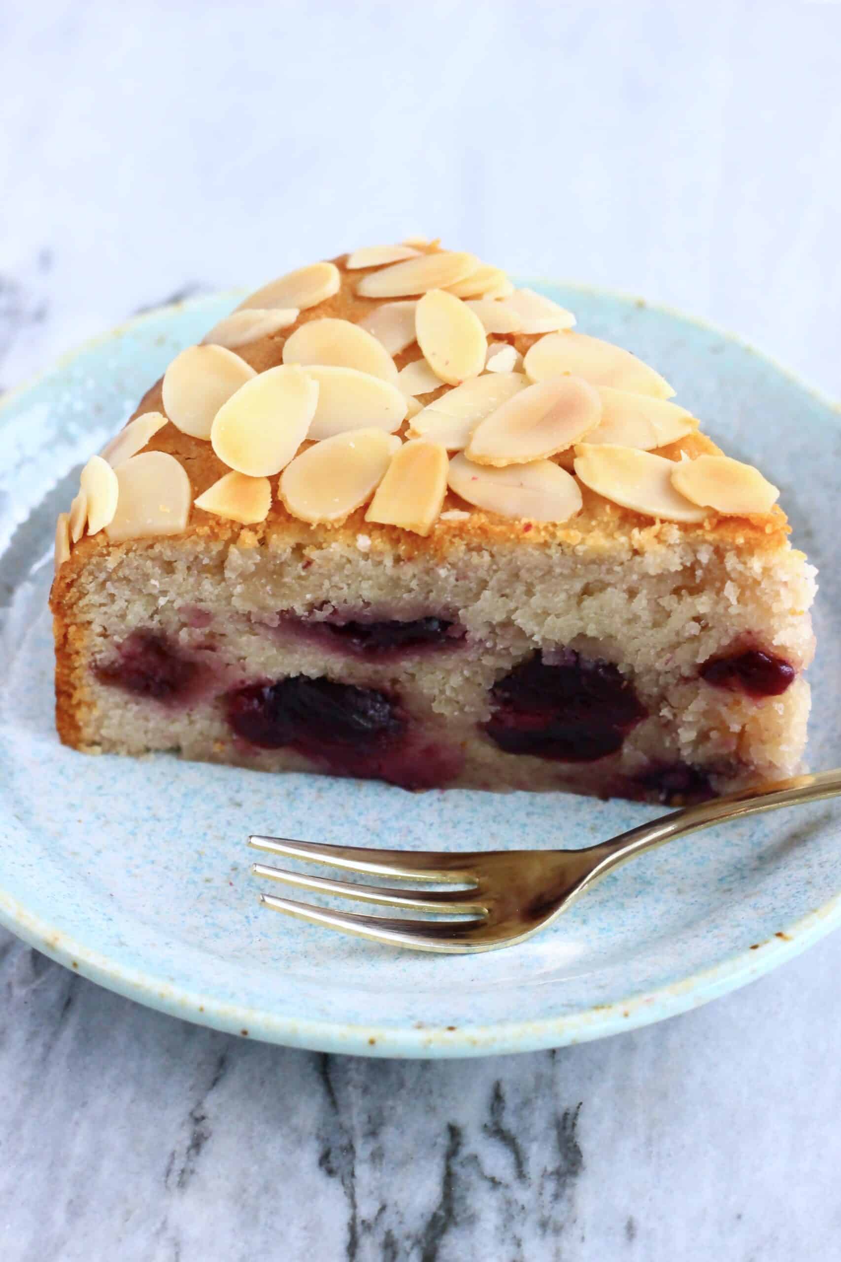 A slice of gluten-free vegan cherry cake on a plate with a fork
