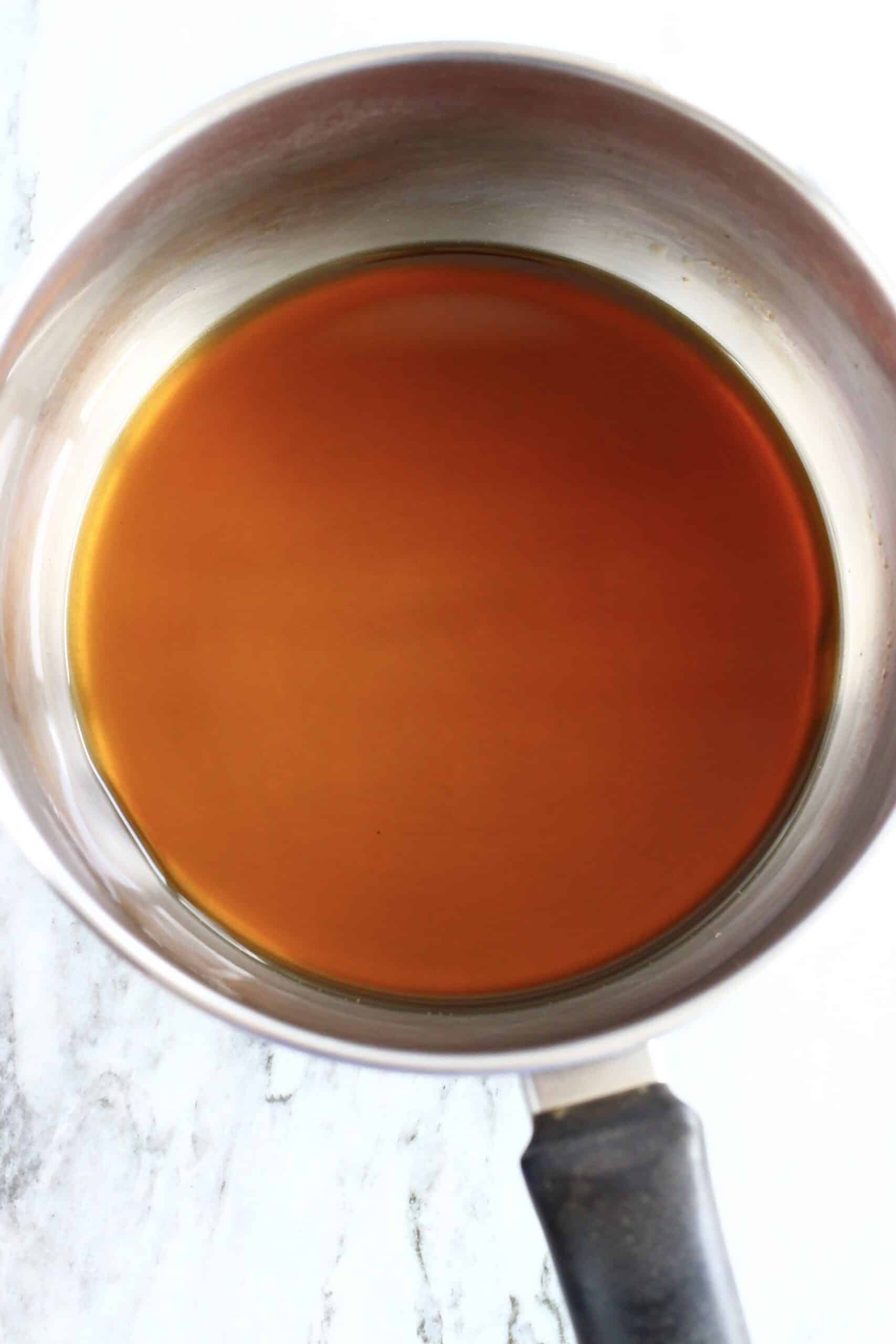 Coconut sugar and water being made into a brown sugar syrup in a pan