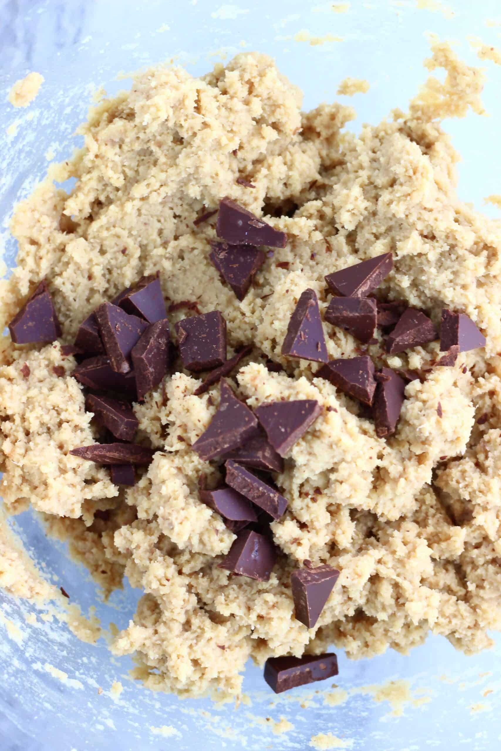 Raw chickpea cookies dough with chocolate chips in a mixing bowl