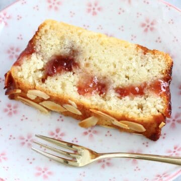 A slice of gluten-free vegan jam marble cake on a plate with a fork