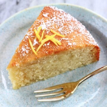 A slice of gluten-free vegan lemon olive oil cake on a plate with a fork