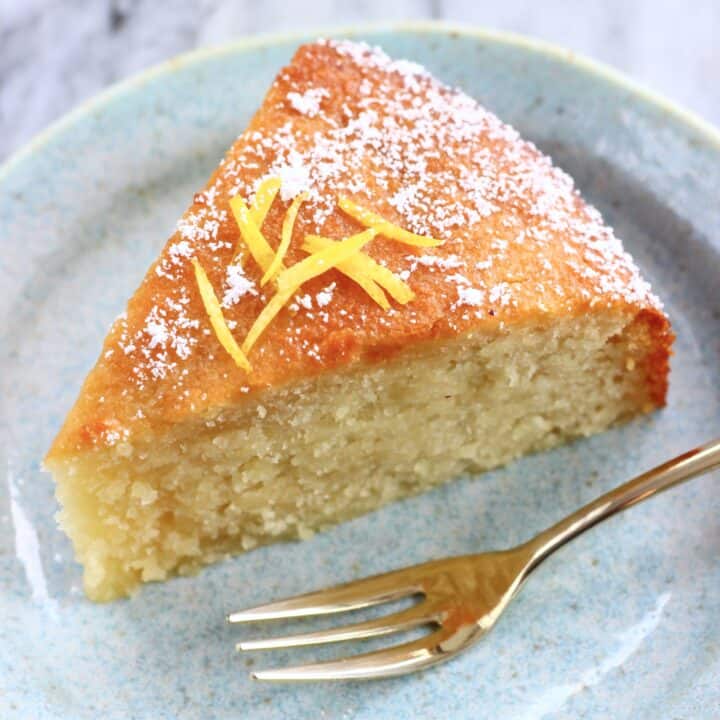 A slice of gluten-free vegan lemon olive oil cake on a plate with a fork