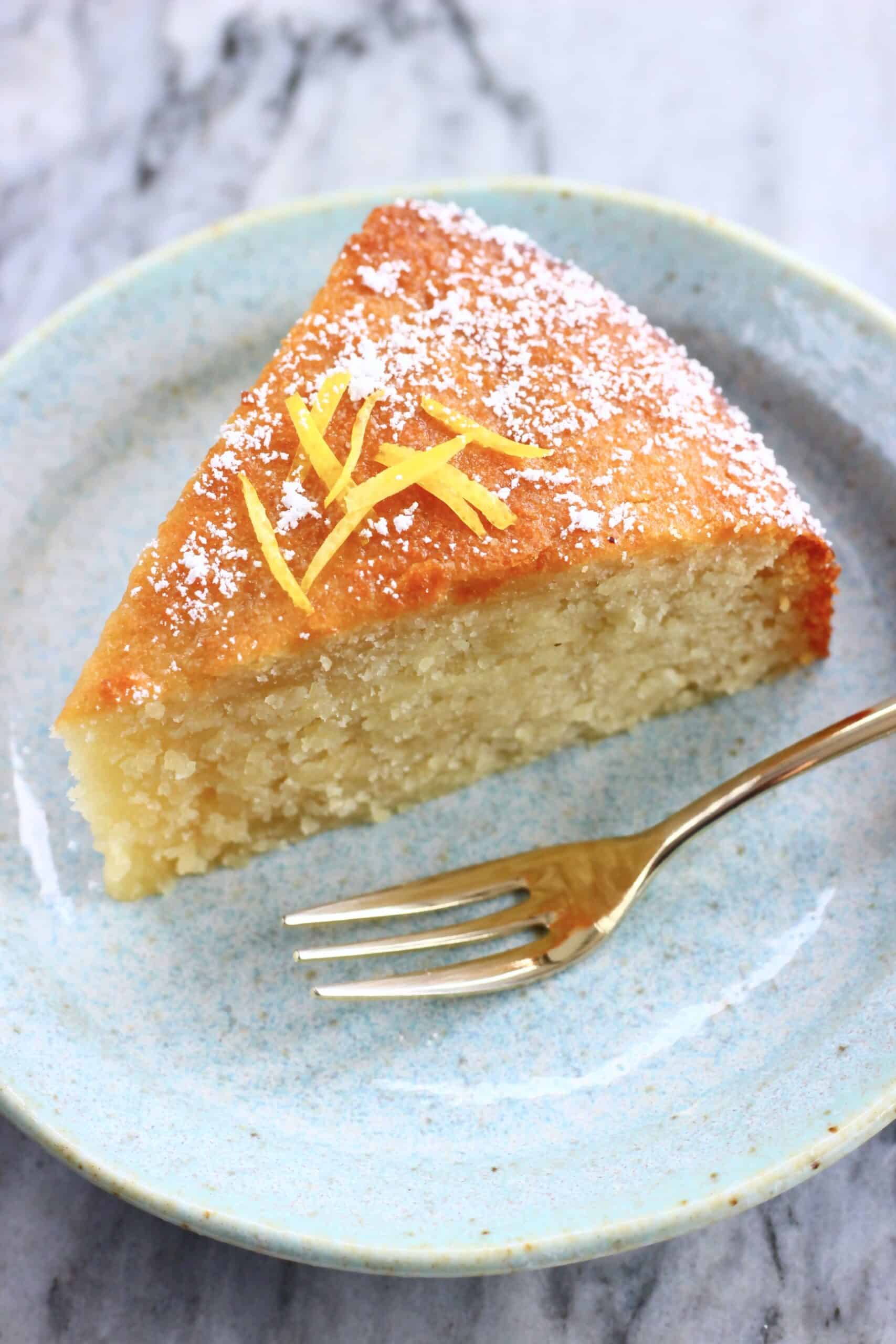A slice of gluten-free vegan lemon olive oil cake on a plate with a fork