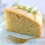 A slice of vegan olive oil yogurt cake on a plate with a fork