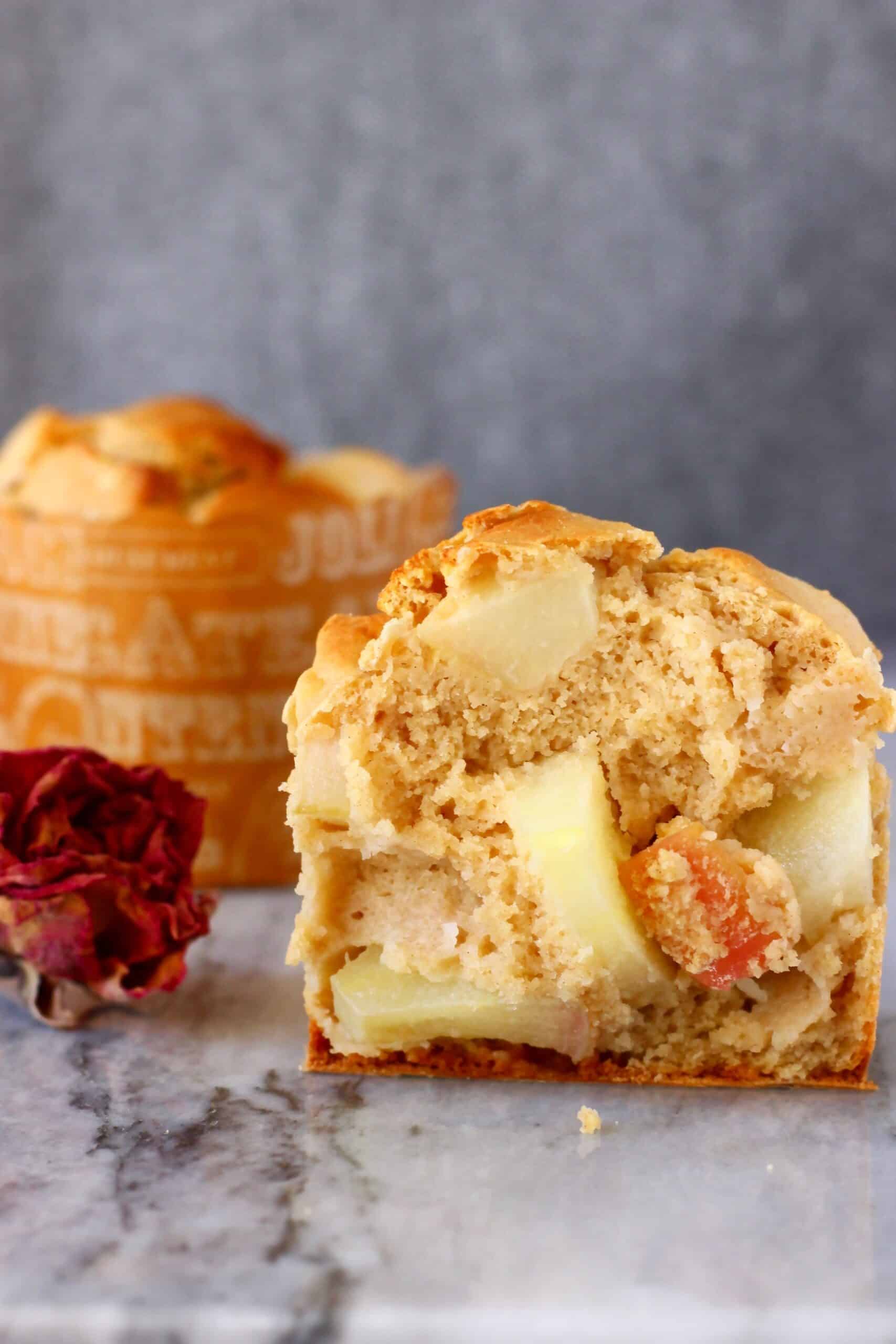 A halved gluten-free vegan apple muffin with another muffin in the background