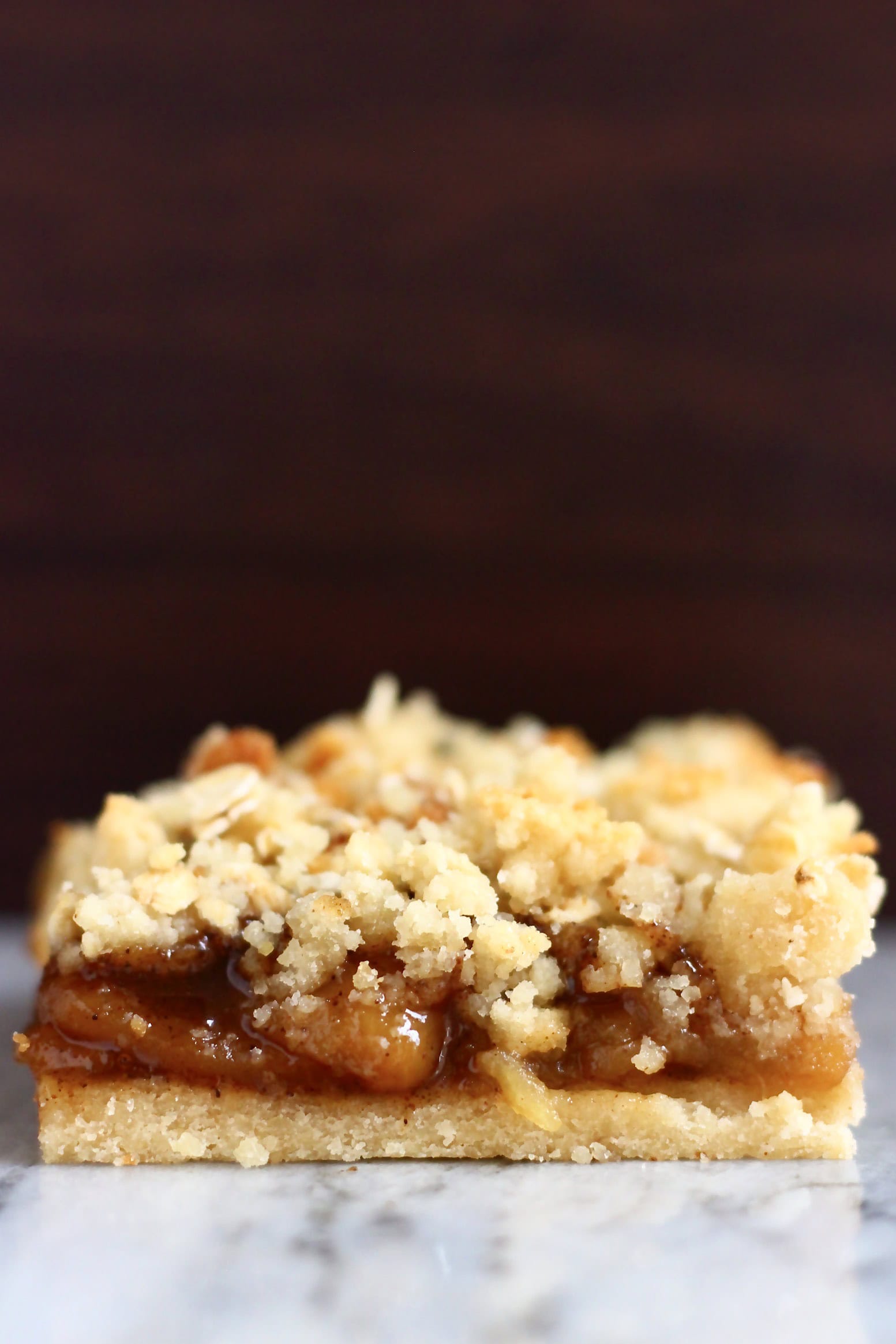 Apple pie bar on a marble slab against a dark brown background